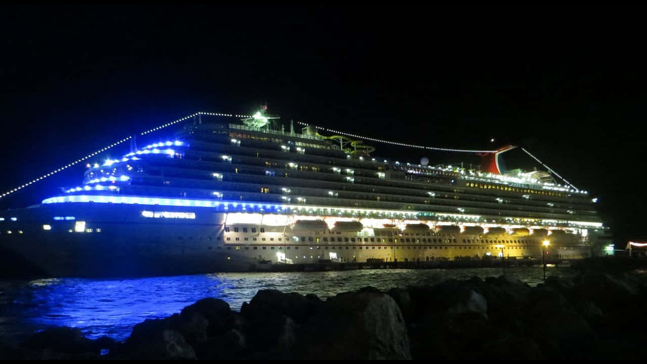 A Large Cruise Ship Docked At Night