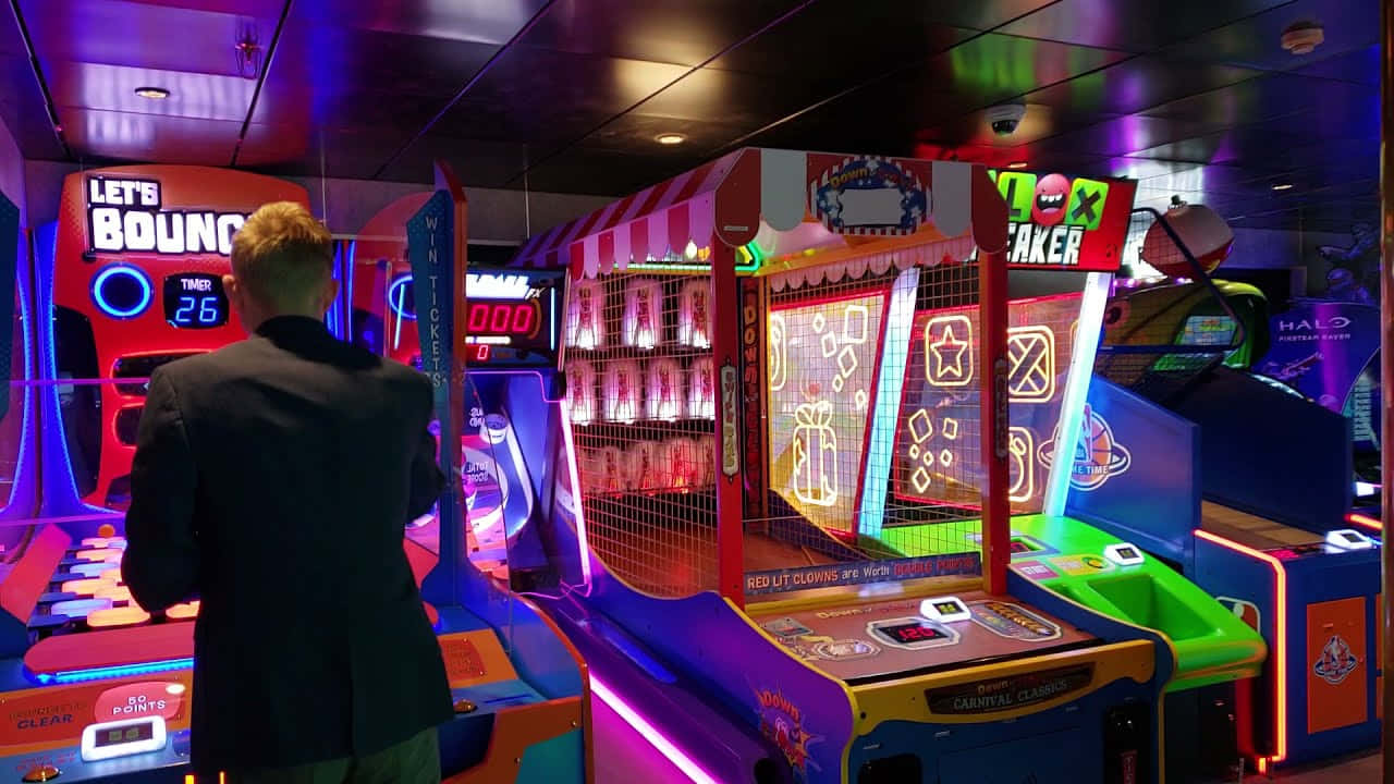 A Man Playing A Game Of Arcade Games