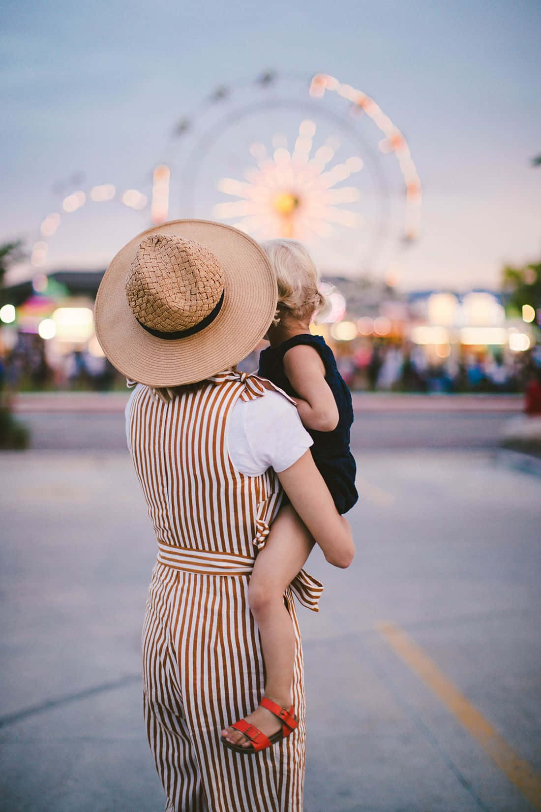 Woman Carrying Her Child At Carnival Picture