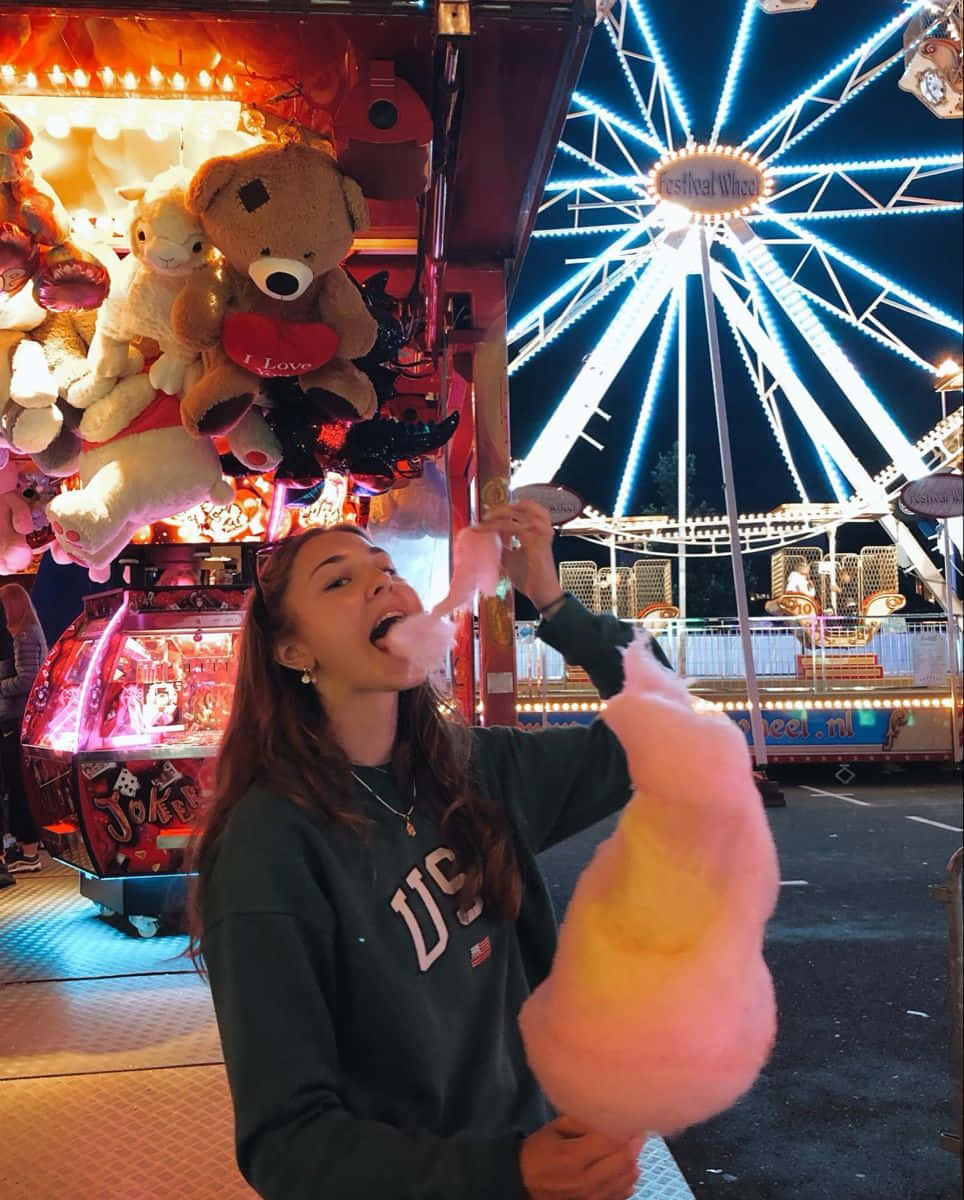 Girl Eating Cotton Candy At Carnival Picture