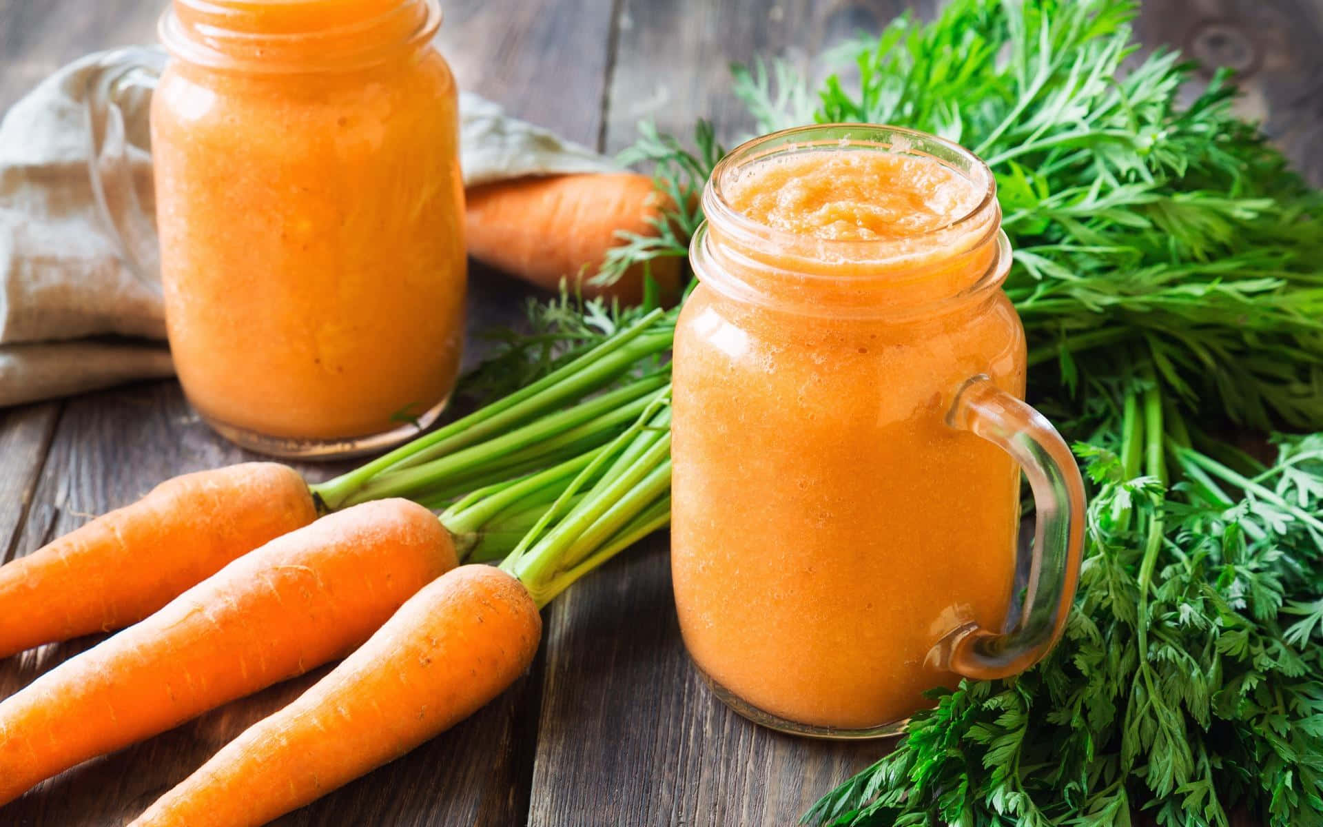 Carrot Juice In Jars On A Wooden Table