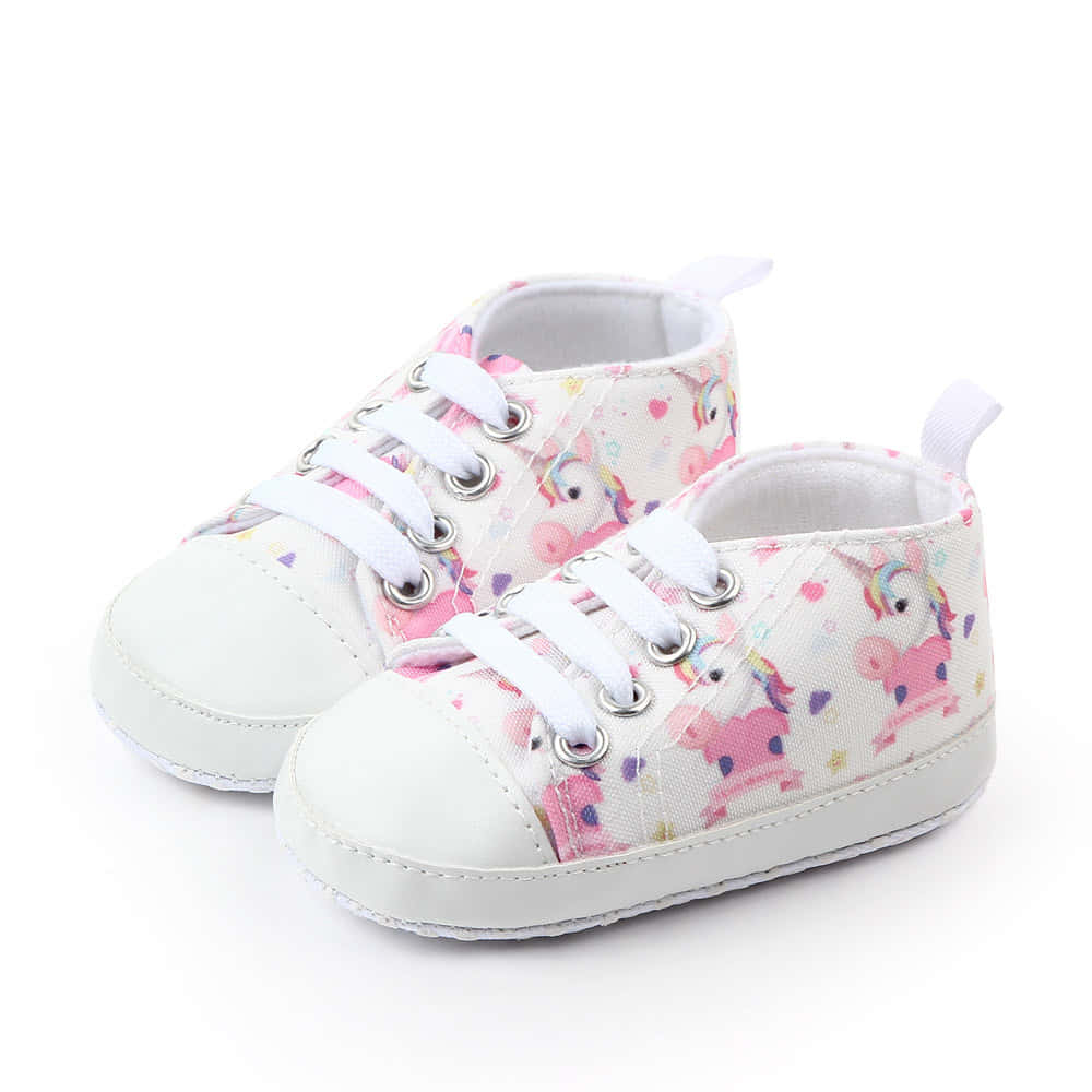 A Pair Of Baby Shoes With Unicorns On Them