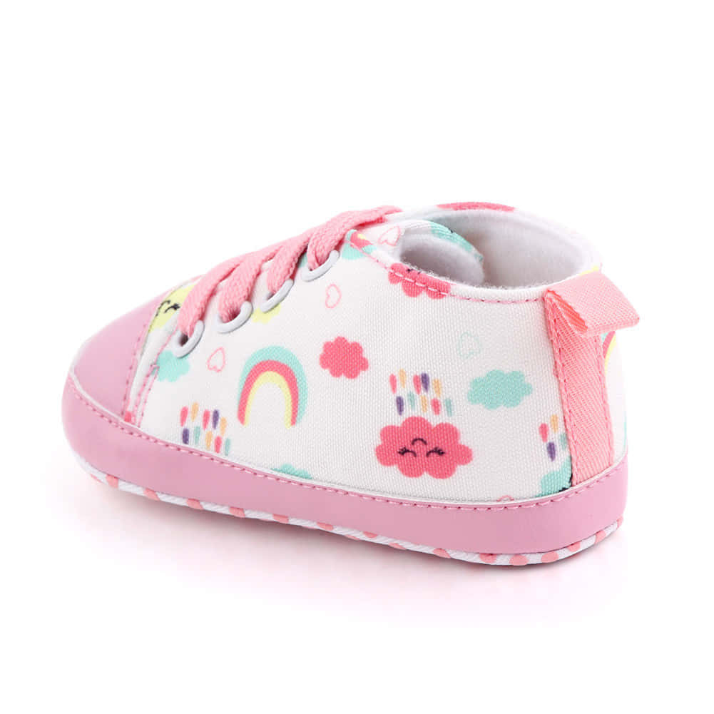 A Pink And White Baby Shoe With Clouds And Rainbows
