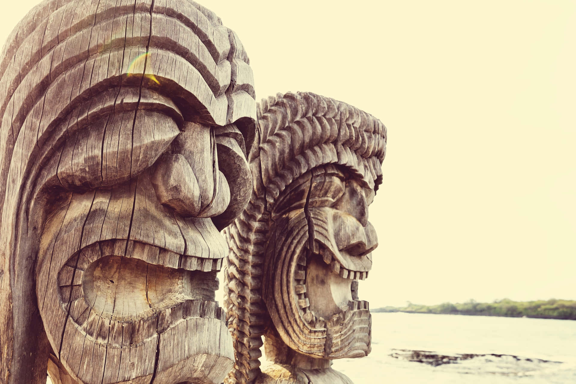 Carved Wooden Tiki Statues Seaside Wallpaper