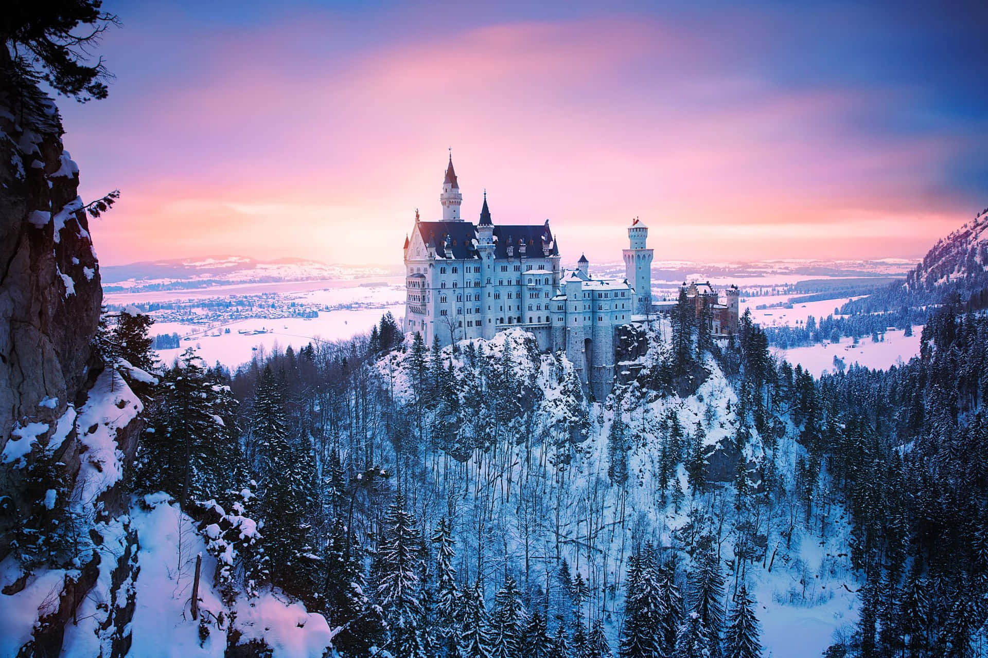 A stunning image of a castle perched atop a hill in the middle of a foggy valley.