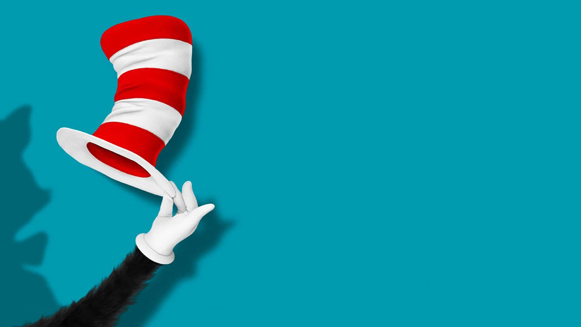 A Cat In The Hat Is Holding Up A Hat