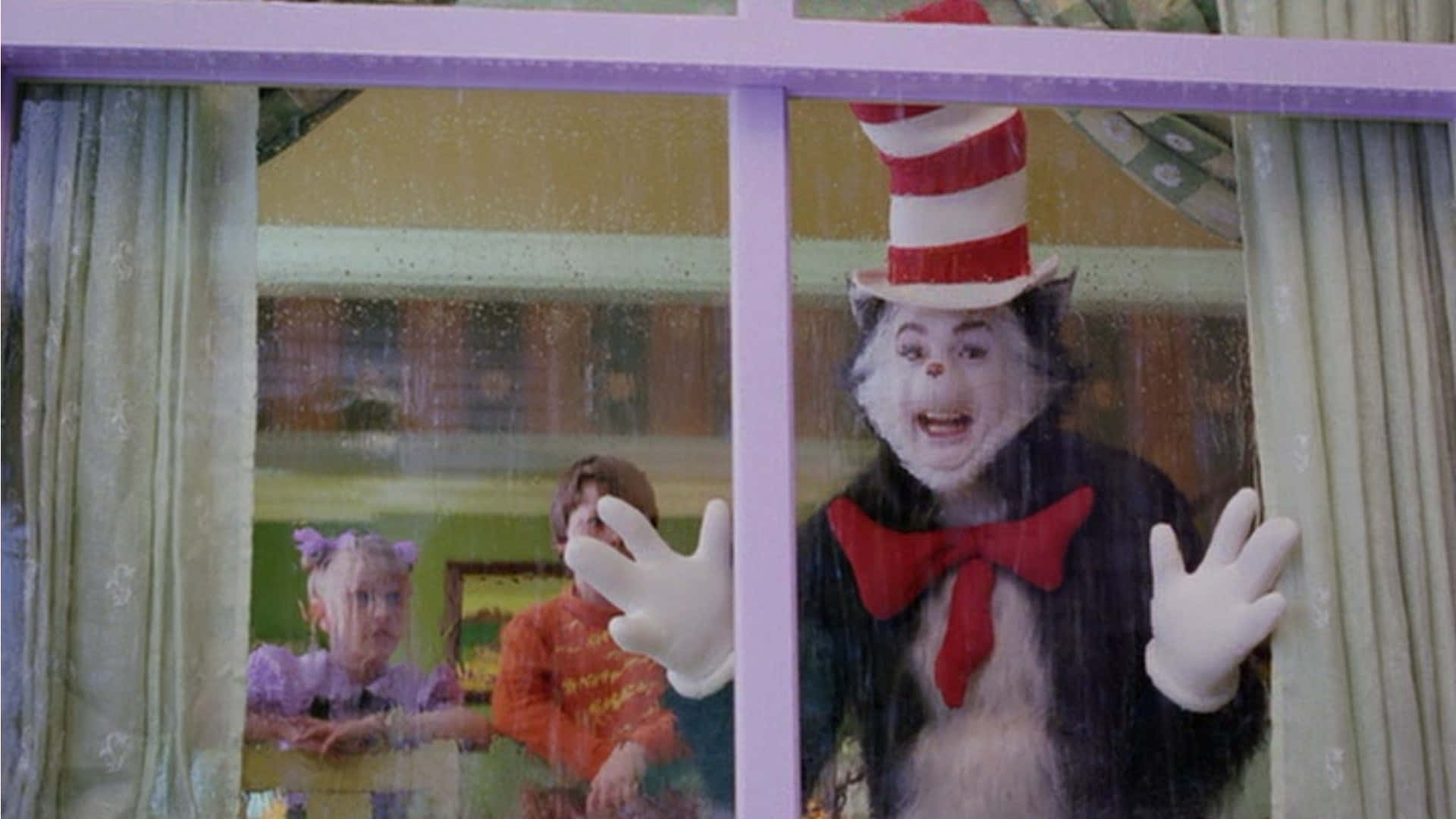 A Cat In The Hat Is Waving Out Of A Window
