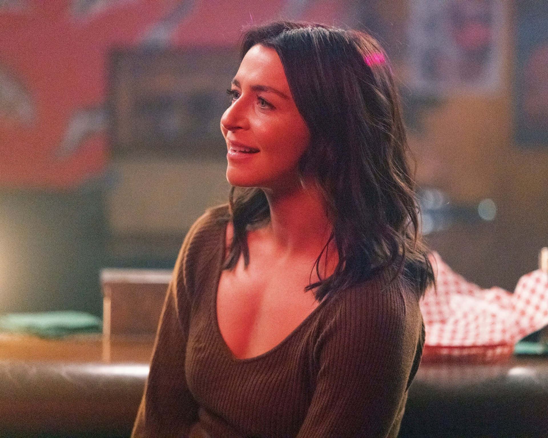 Caterina Scorsone Glimlachend In Bar Setting Achtergrond