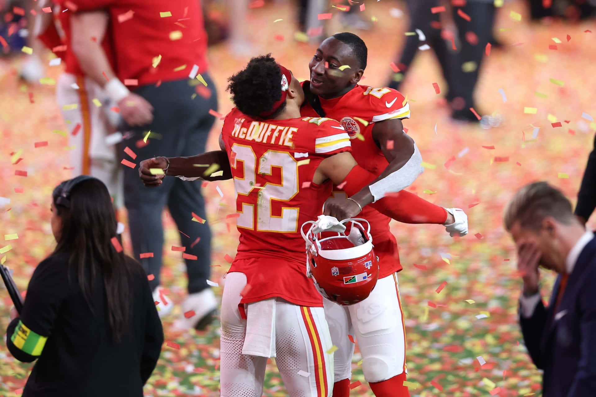 Celebratory Hug Amidst Confetti Kansas City Chiefs Wallpaper