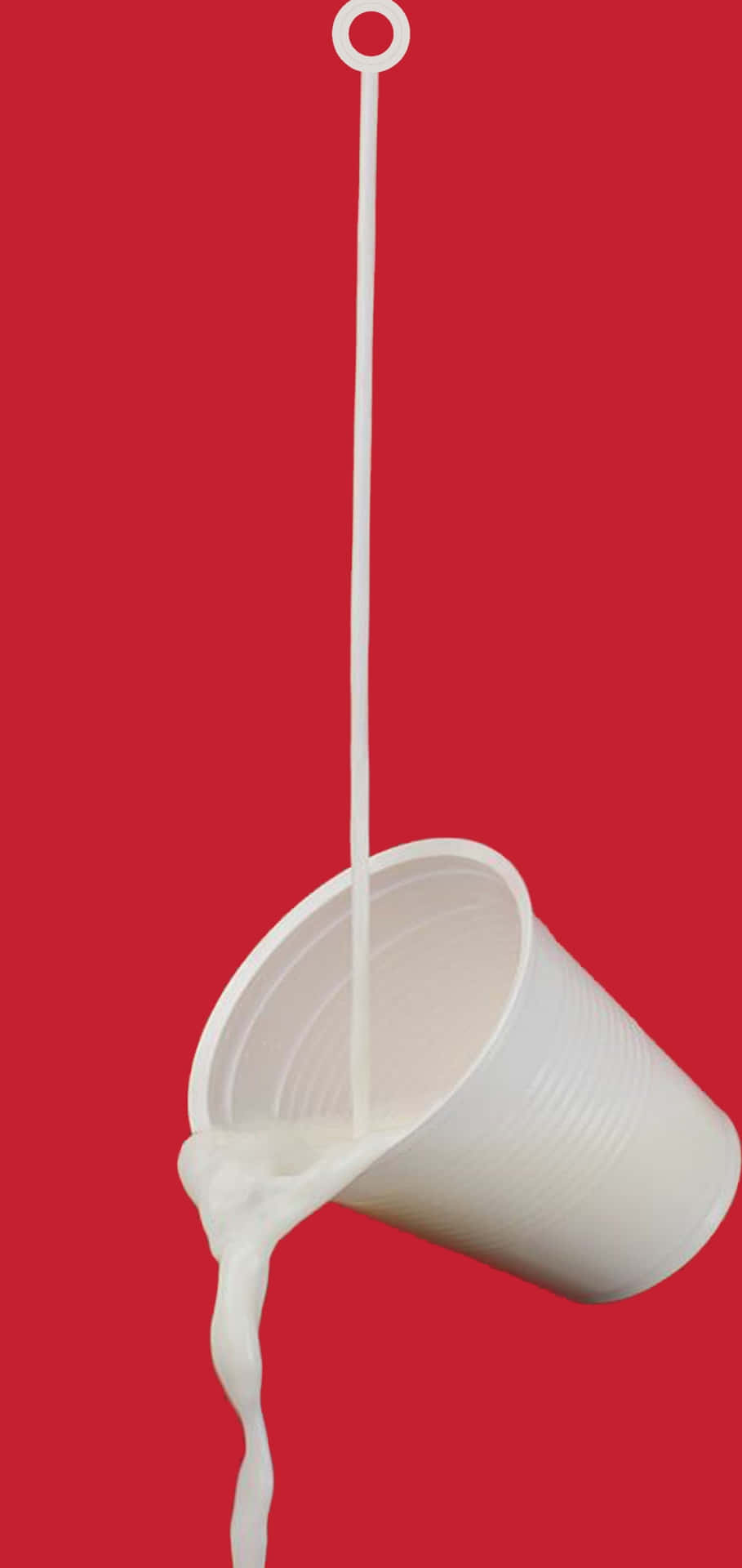 Einetasse Milch Tropft Von Einem Roten Hintergrund. Wallpaper