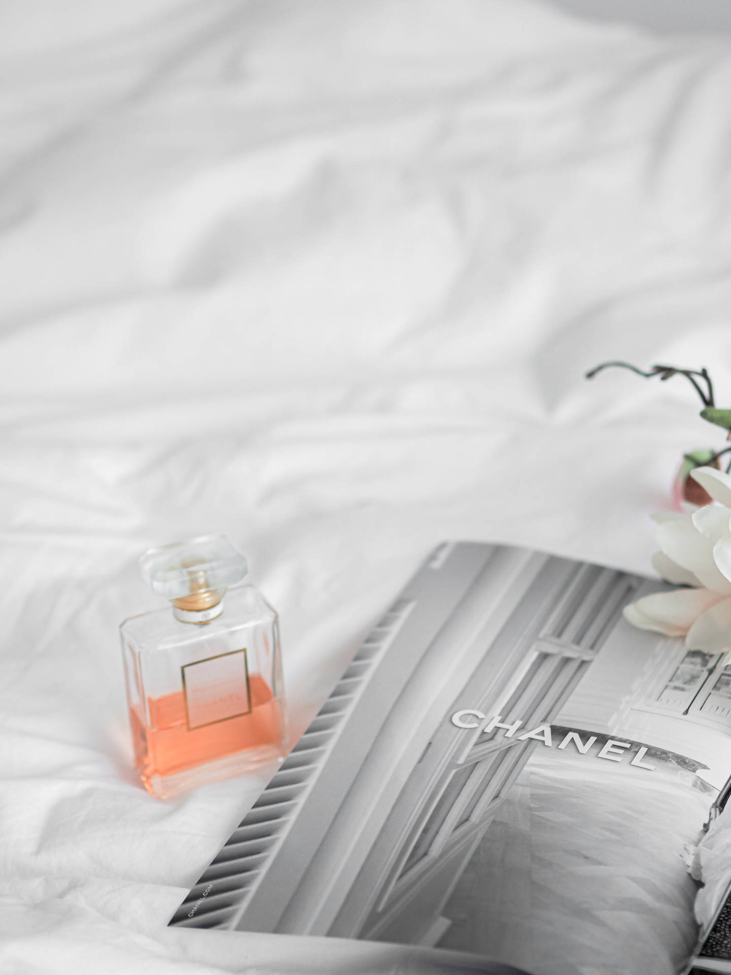 Chanel Mademoiselle Perfume With Magazine Background