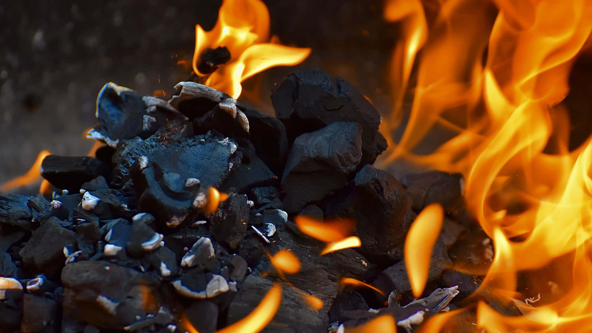 A Close Up Of A Fire With Coal And Flames