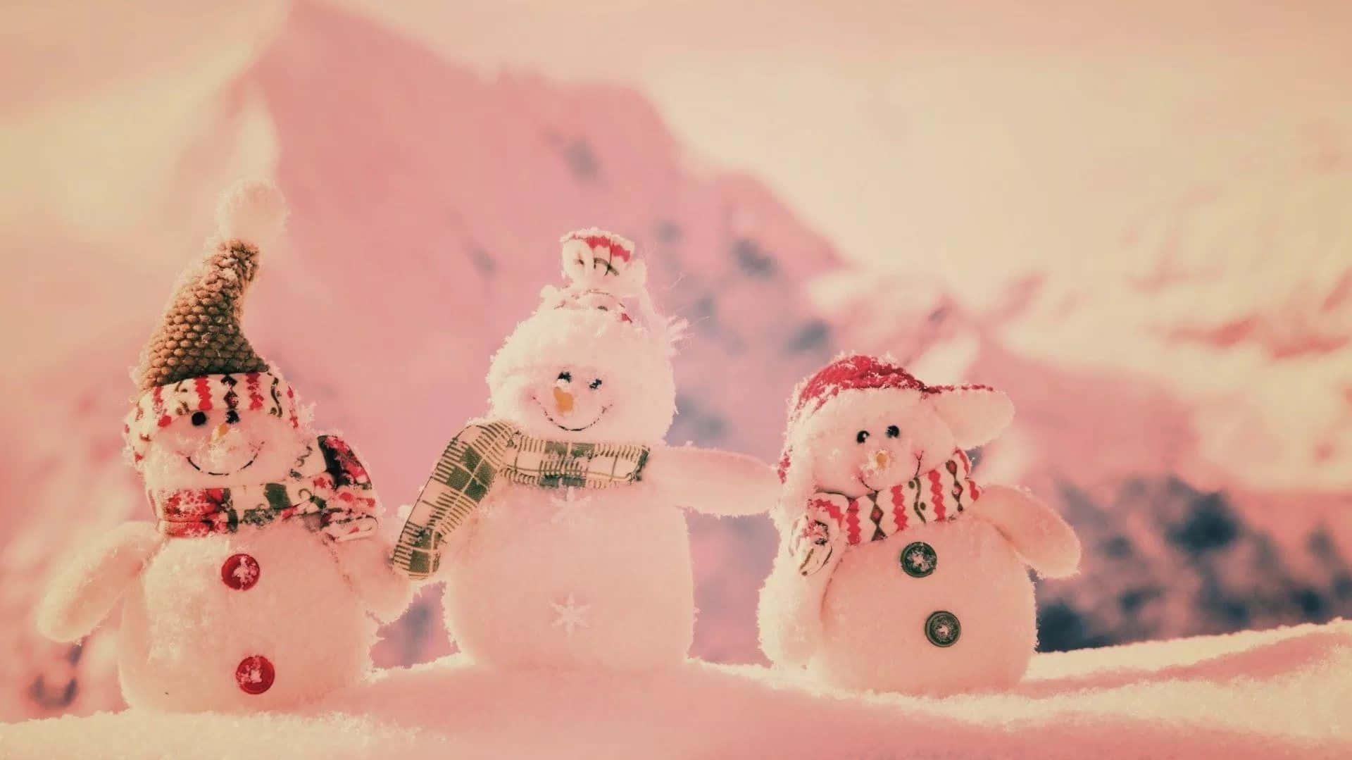 Charming Trioof Snowmenin Pink Hues Wallpaper