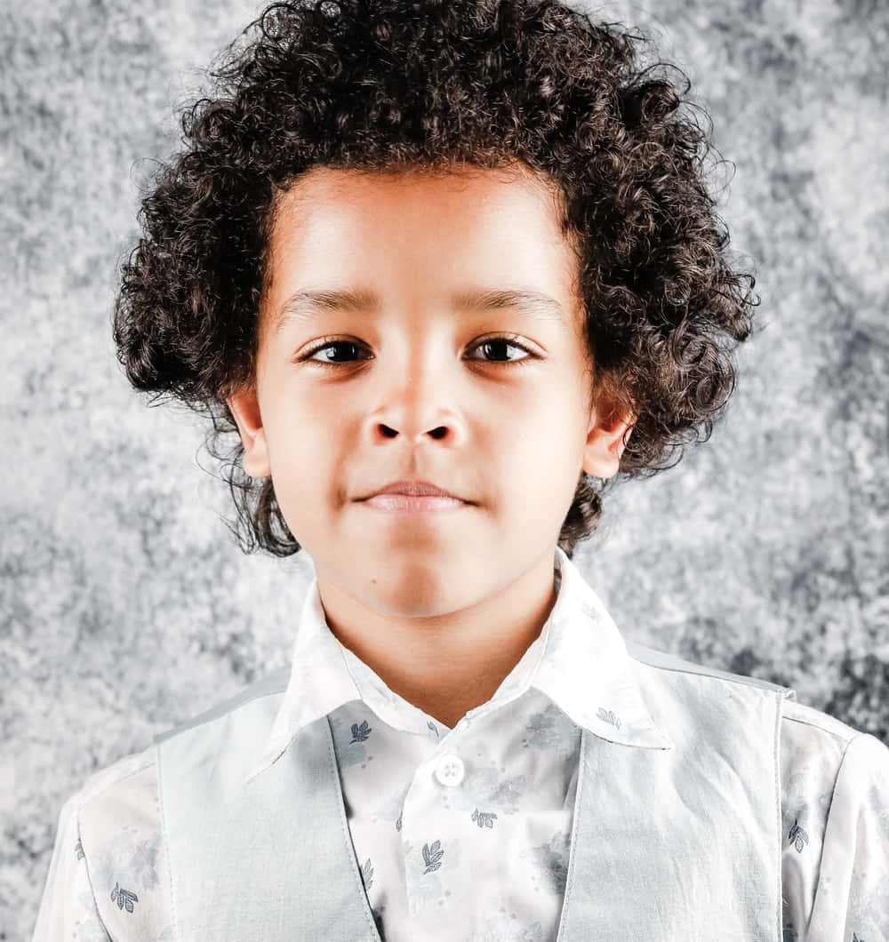 Charming Young Boywith Curly Hair Wallpaper