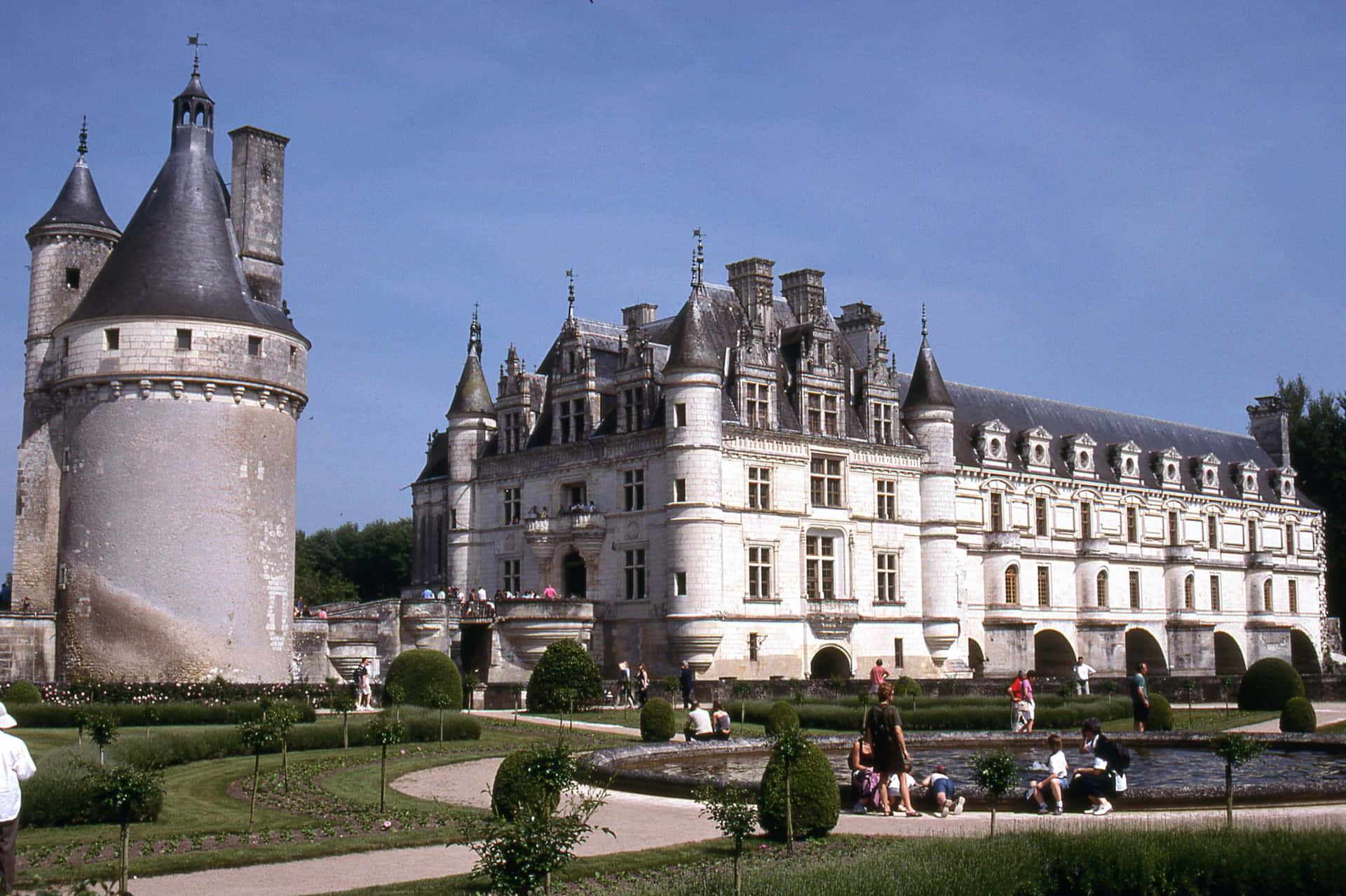 Chateau De Chenonceau With Tourists Background