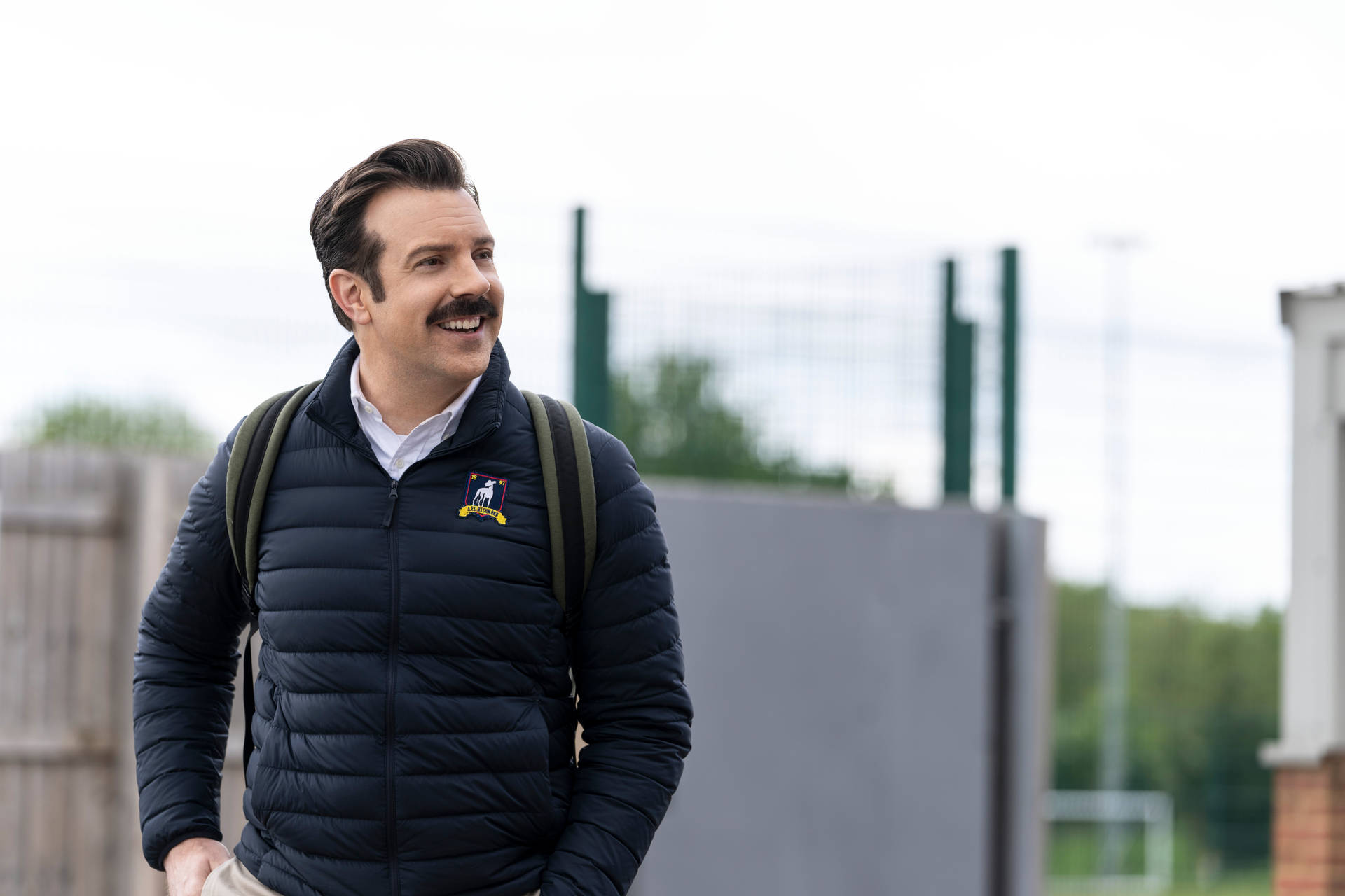 Cheerful Ted Lasso Wearing Jacket Wallpaper