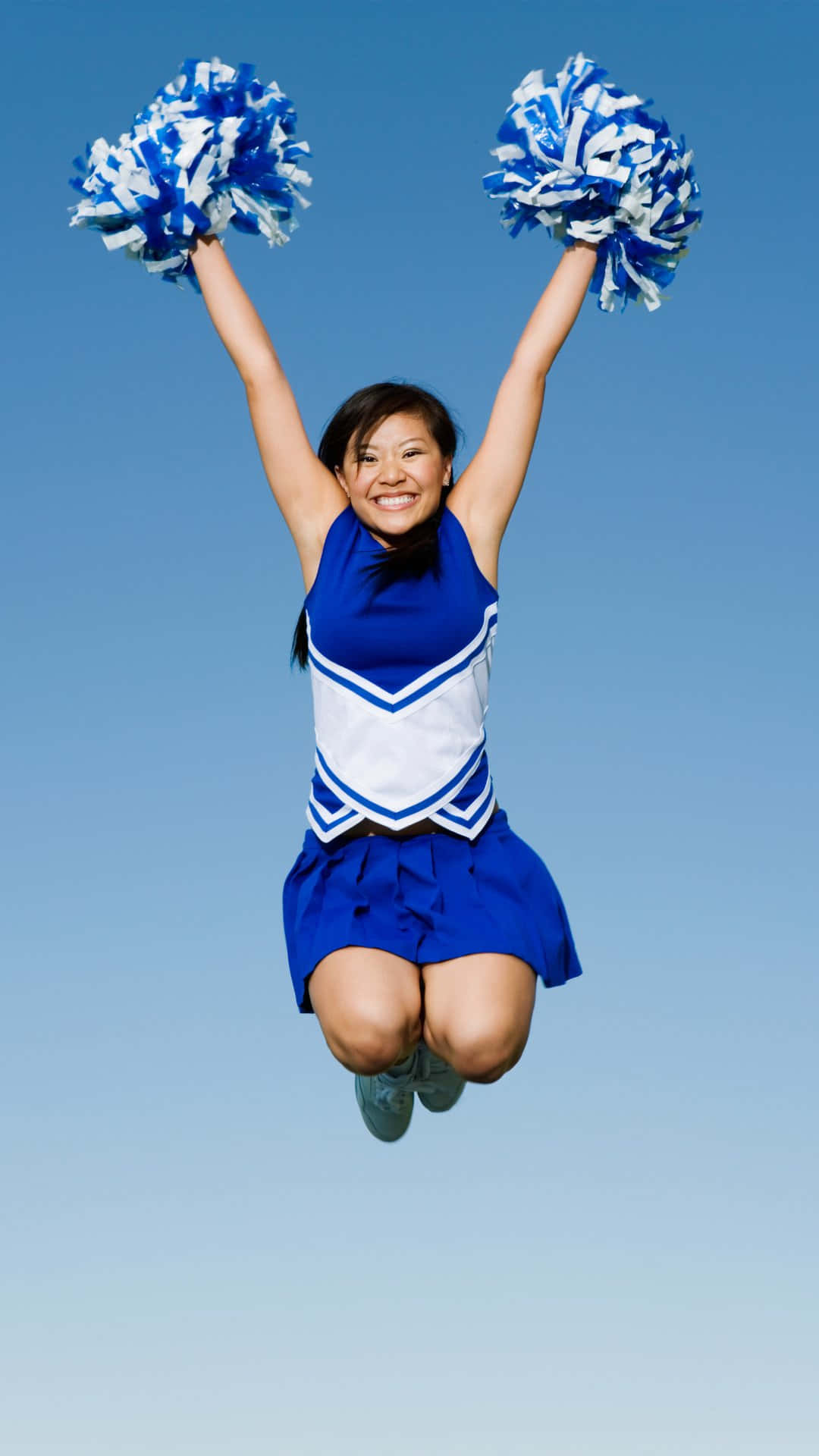 Cheerleader Jumping With Pom Poms Wallpaper