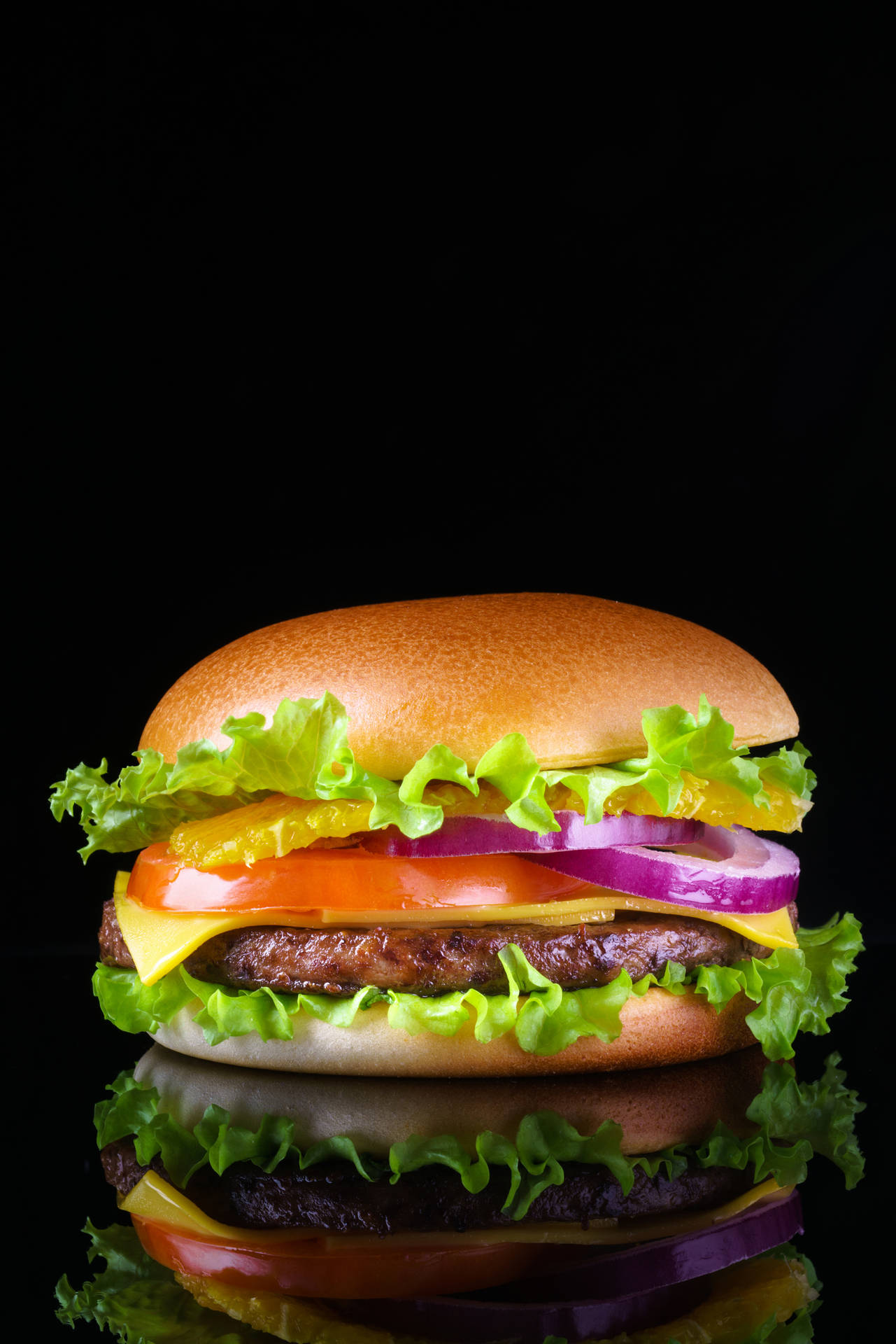 Caption: A Delectable Cheeseburger on a Dark Backdrop Wallpaper