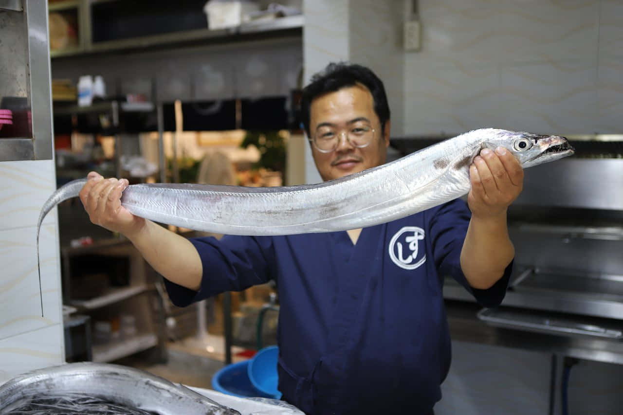 Chef Holding Large Cutlassfish Wallpaper