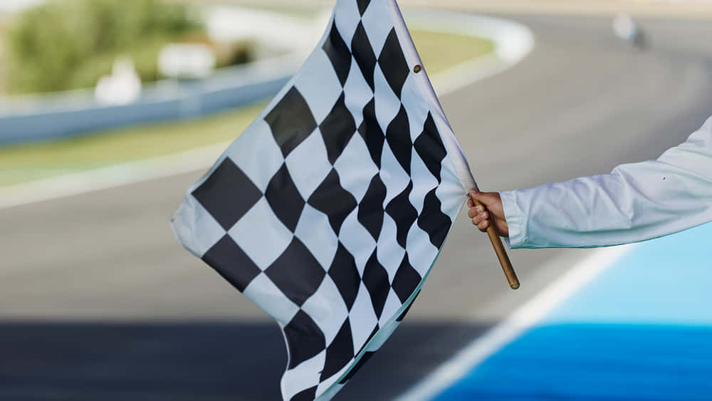 Chequered Flag Waving in the Wind at a Motorsport Race Wallpaper