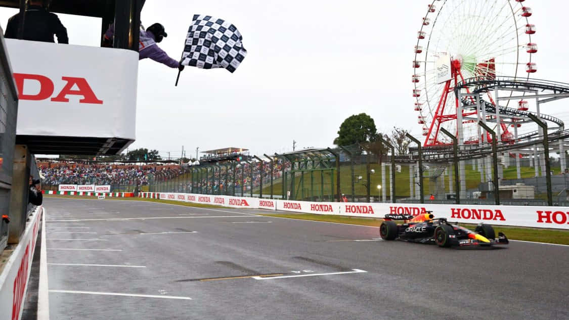 Caption: Chequered Flag Waving on a Racing Track Wallpaper