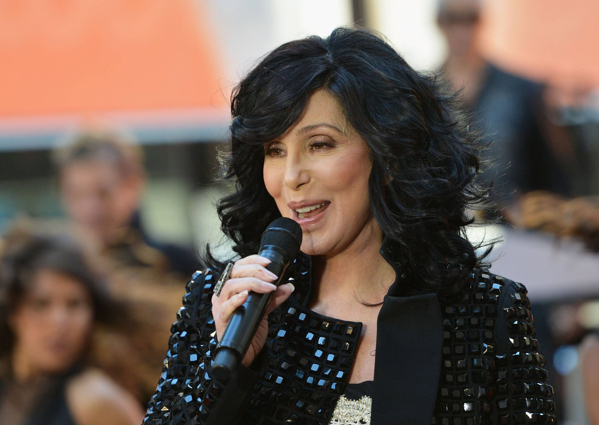 Legendary Singer Cher Performing on Stage with Microphone Wallpaper