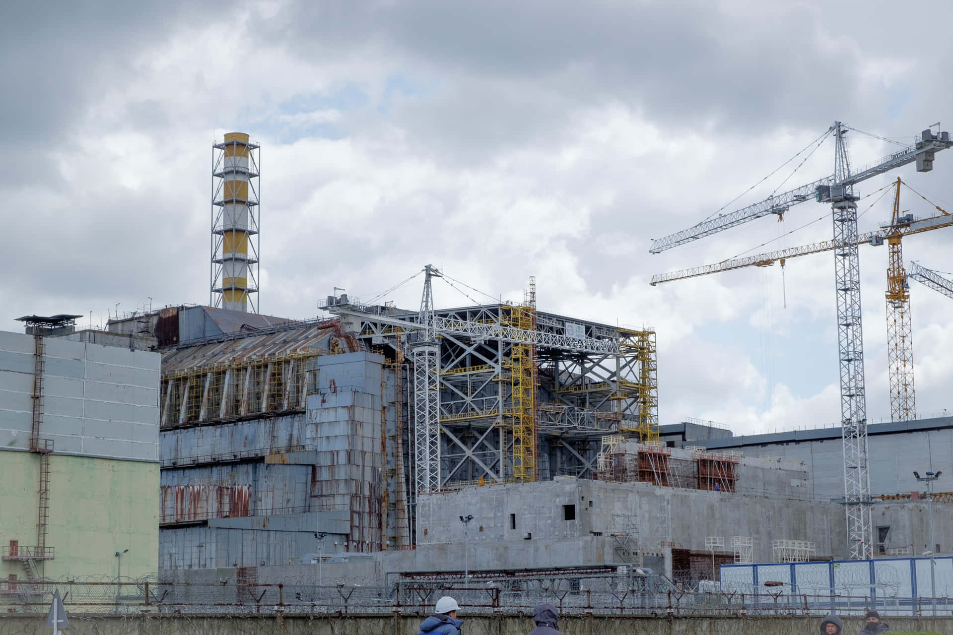 A Large Nuclear Power Plant With Cranes And Construction Workers
