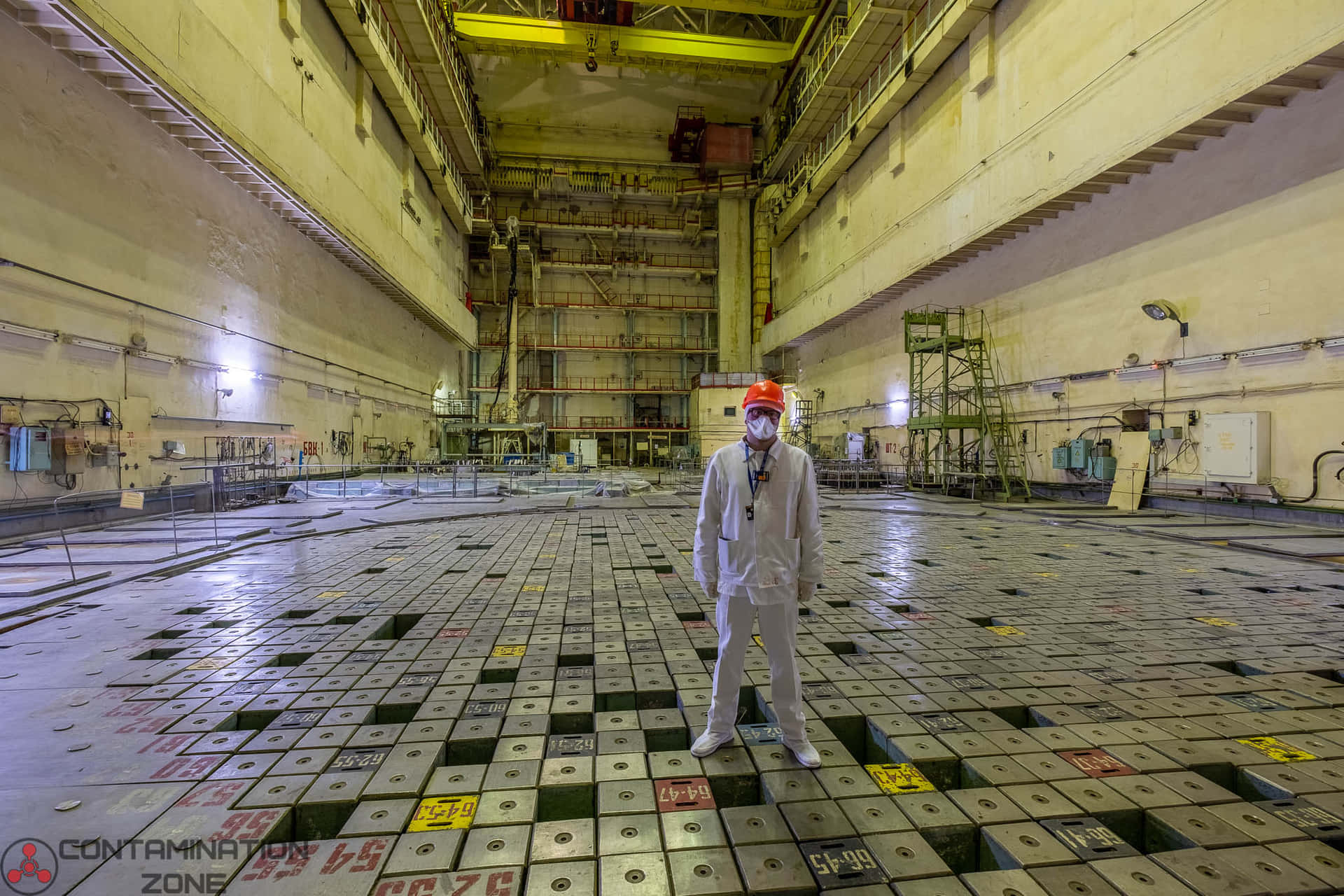 A Man In A Protective Suit Standing In A Large Room