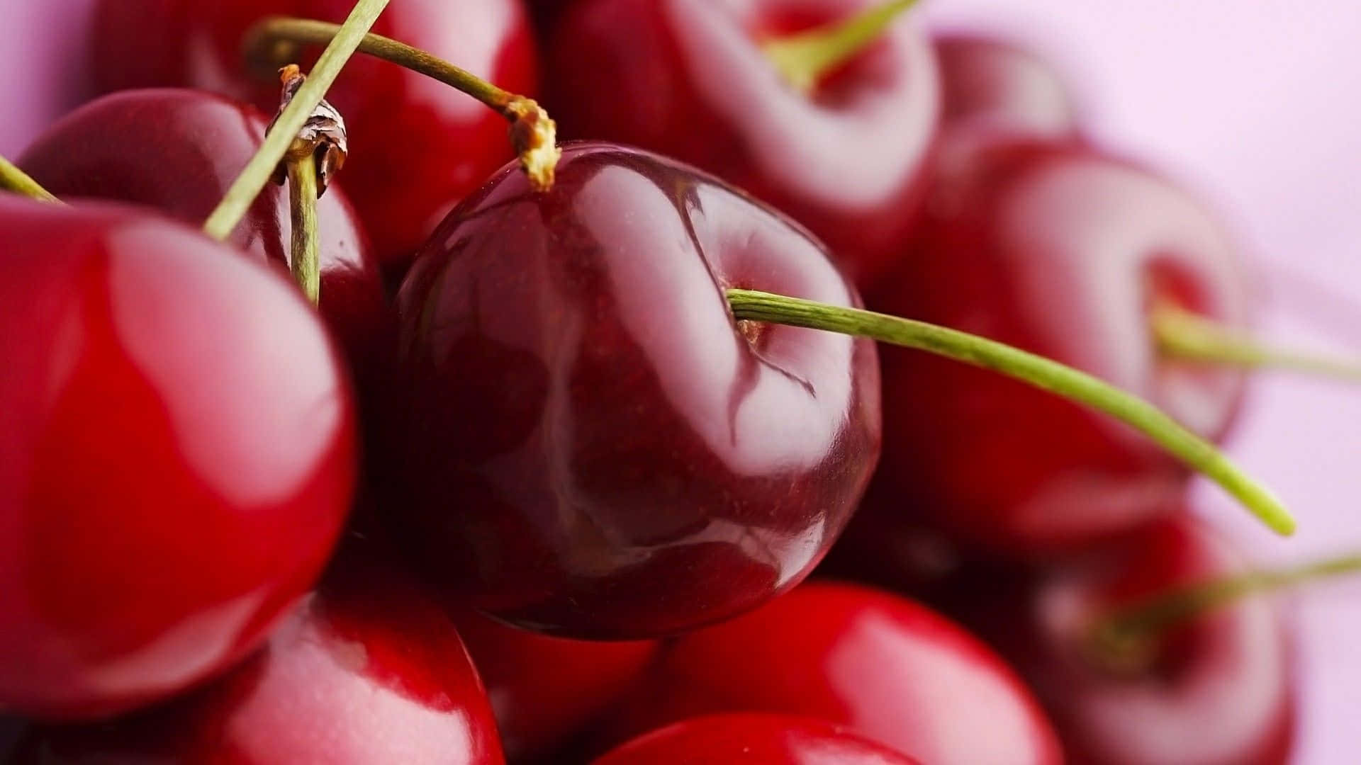 A Bunch Of Cherries Are Arranged On A Purple Surface