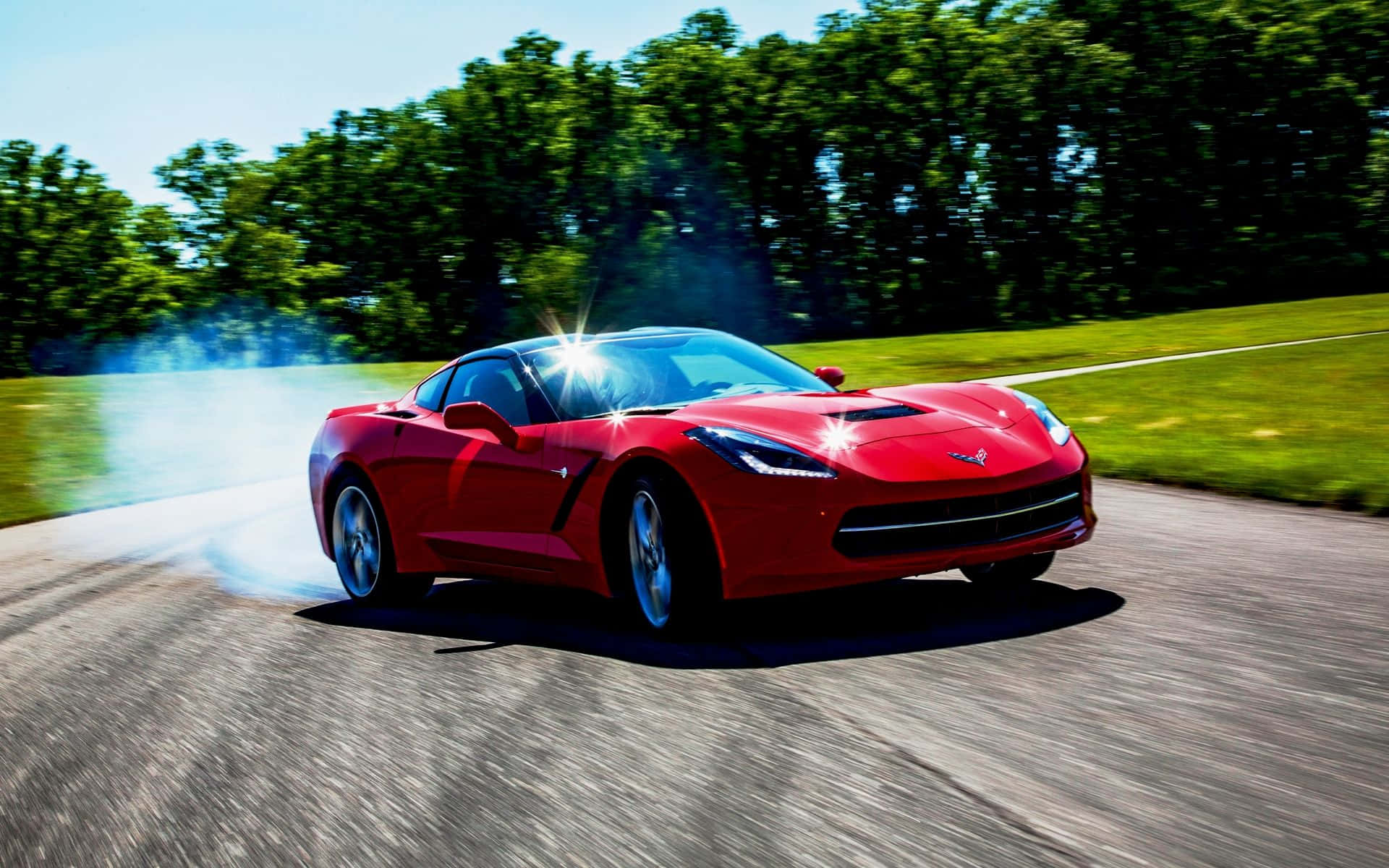 Sleek Chevrolet Corvette Stingray Roaring on the Open Road Wallpaper