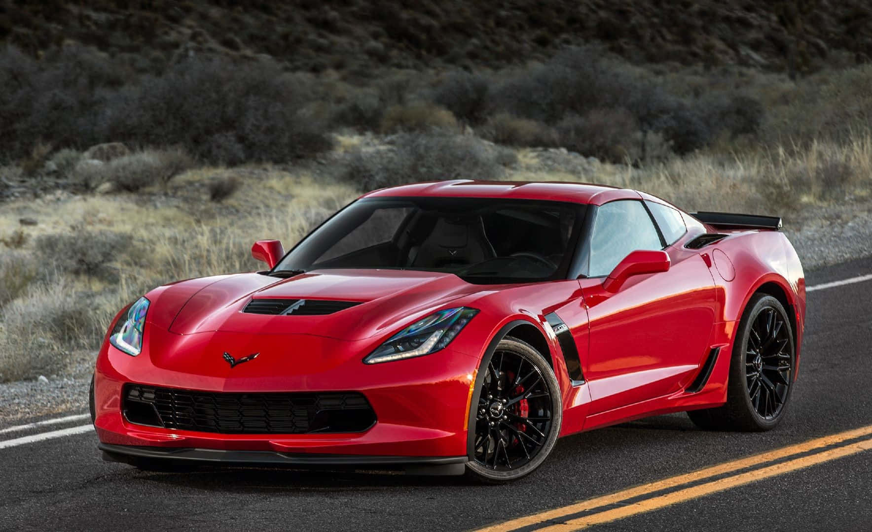 Sleek and Powerful Chevrolet Corvette Z06 on the Open Road Wallpaper