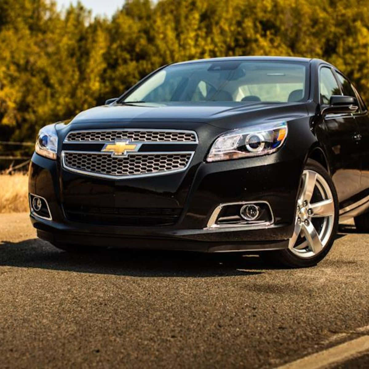 The Black Chevrolet Malibu Is Parked On The Road Wallpaper