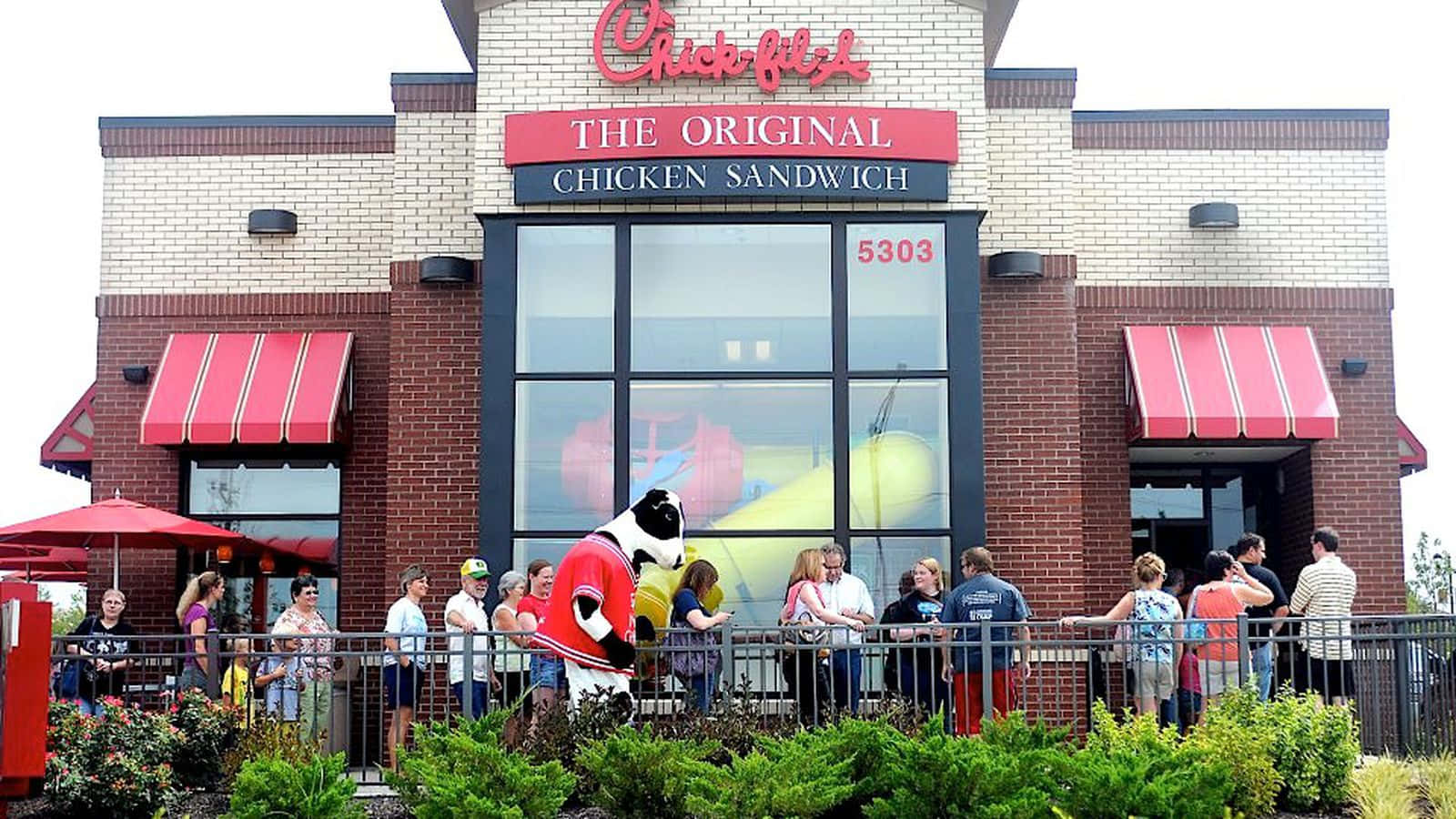 A Group Of People Are Standing Outside Of A Chick-fil-a Restaurant
