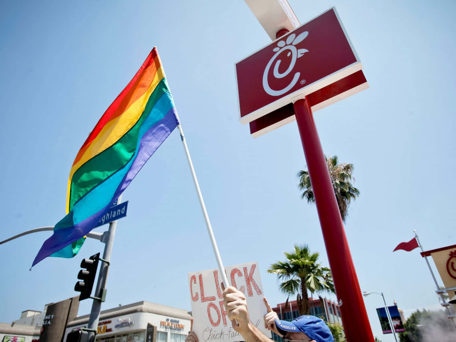 A Man Holding A Rainbow Flag In Front Of A Chinese Restaurant