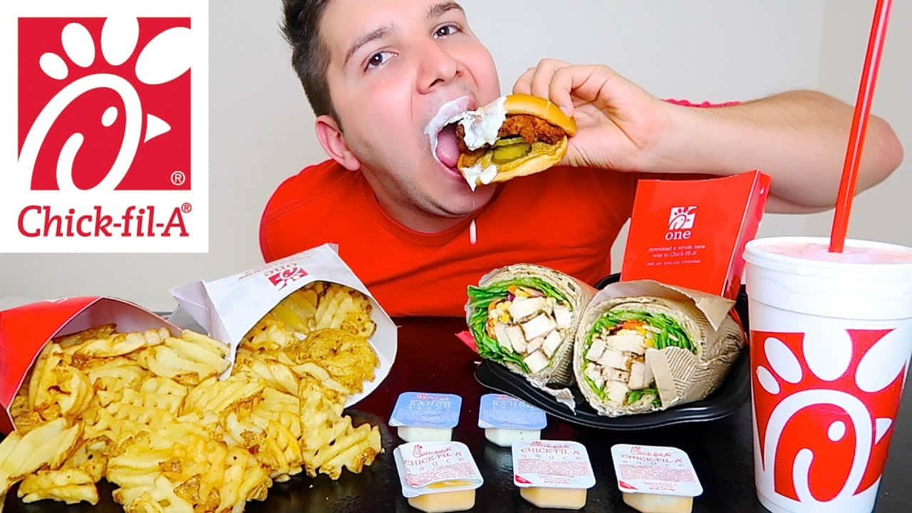 Chickfila - A Man Eating A Chicken Wrap And Fries