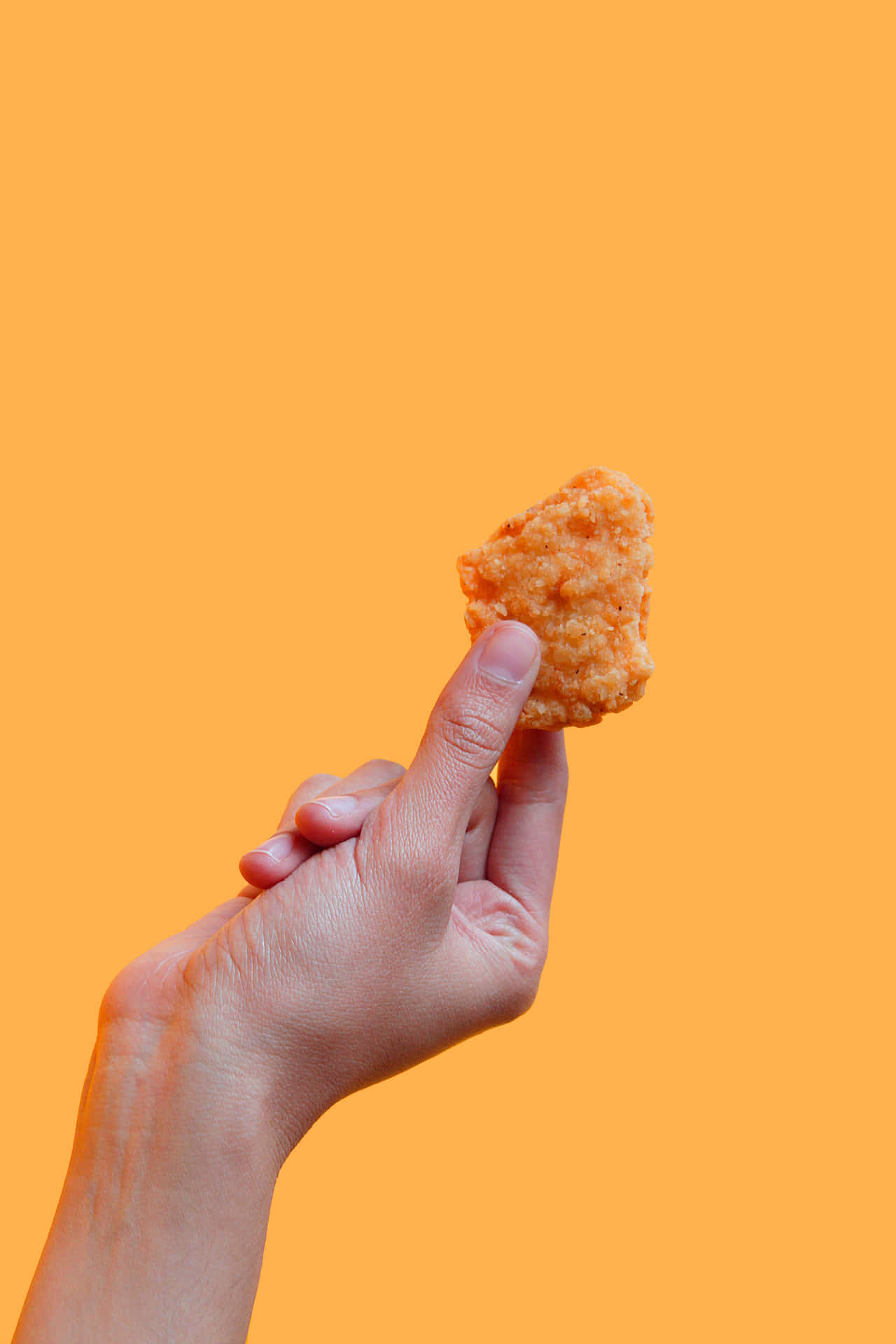 A Person Holding A Piece Of Fried Chicken Wallpaper
