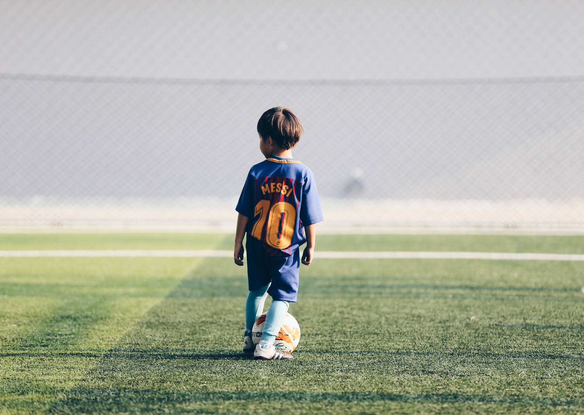 A young hopeful looks forward to one day wearing Lionel Messi's jersey. Wallpaper
