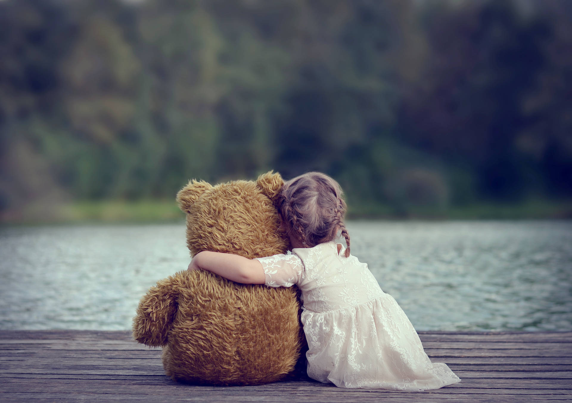Barnsom Kramar En Teddybjörn. (this Would Be A Caption For A Wallpaper With An Image Of A Child Hugging A Teddy Bear.) Wallpaper