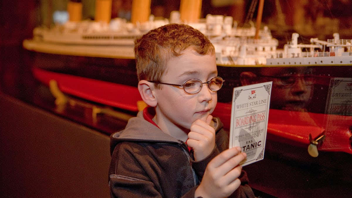Child With Ticket At Rms Titanic Museum Wallpaper