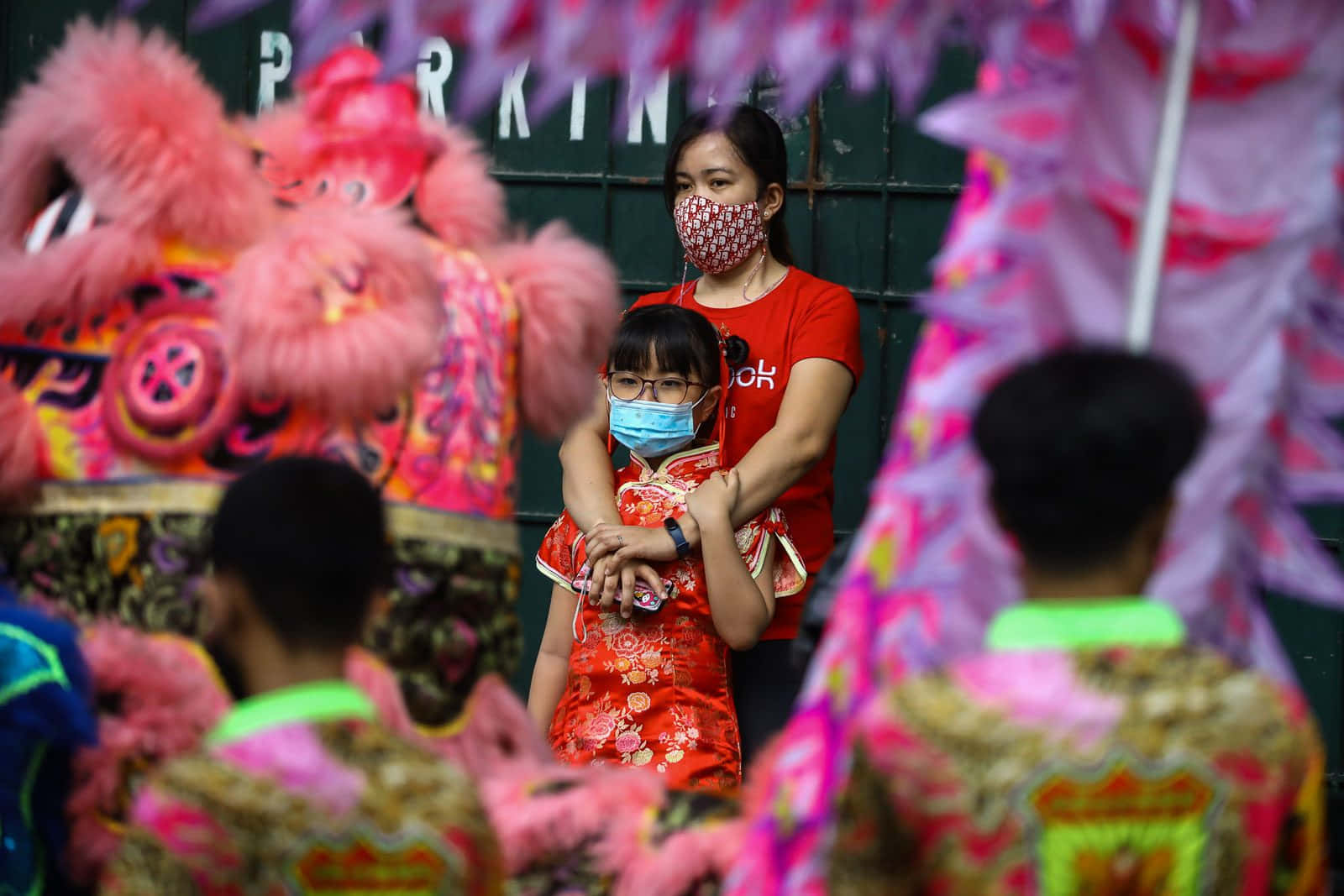 Enkvinde Og Et Barn Iført Masker Til En Kinesisk Festival.