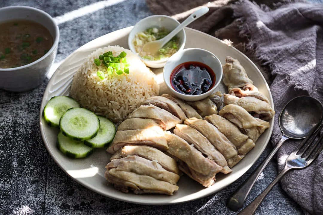 A Plate Of Chicken With Rice And Cucumbers
