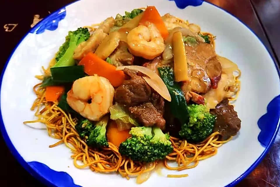 A Plate Of Noodles With Shrimp, Vegetables And Meat