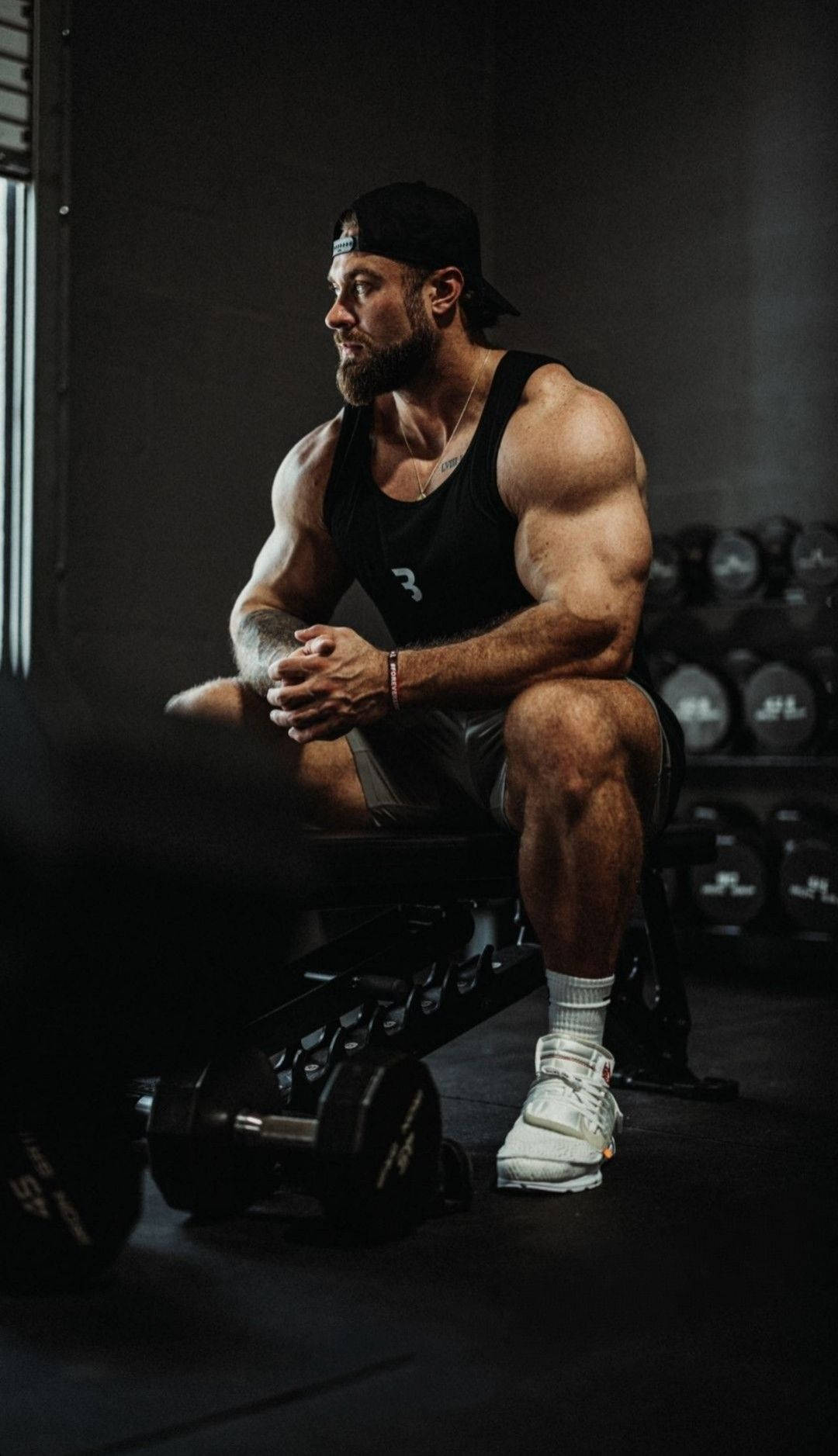 Chris Bumstead Sitting On Weight Bench Wallpaper