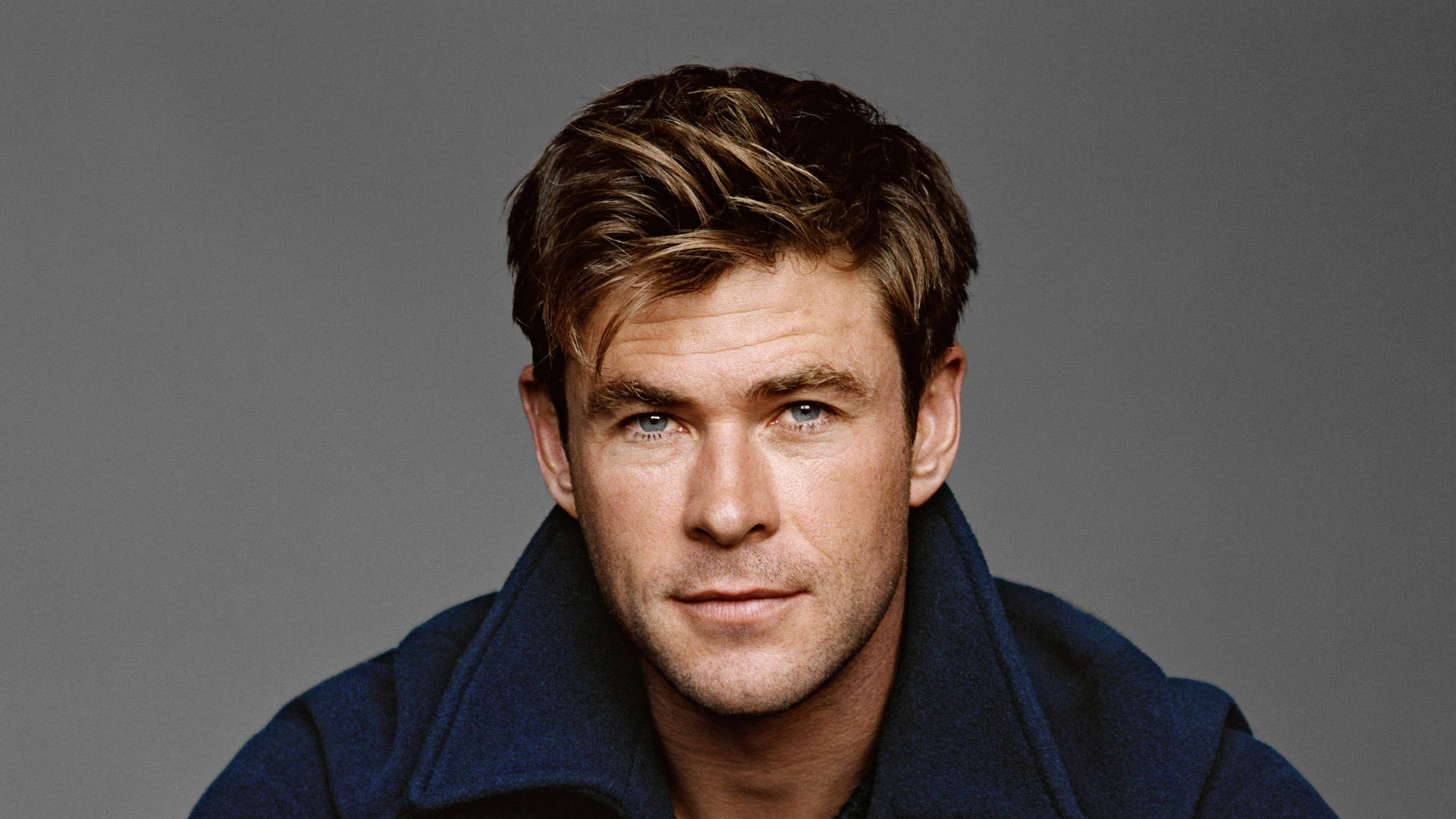 Chris Hemsworth strikes a pose in a blue jacket. Wallpaper