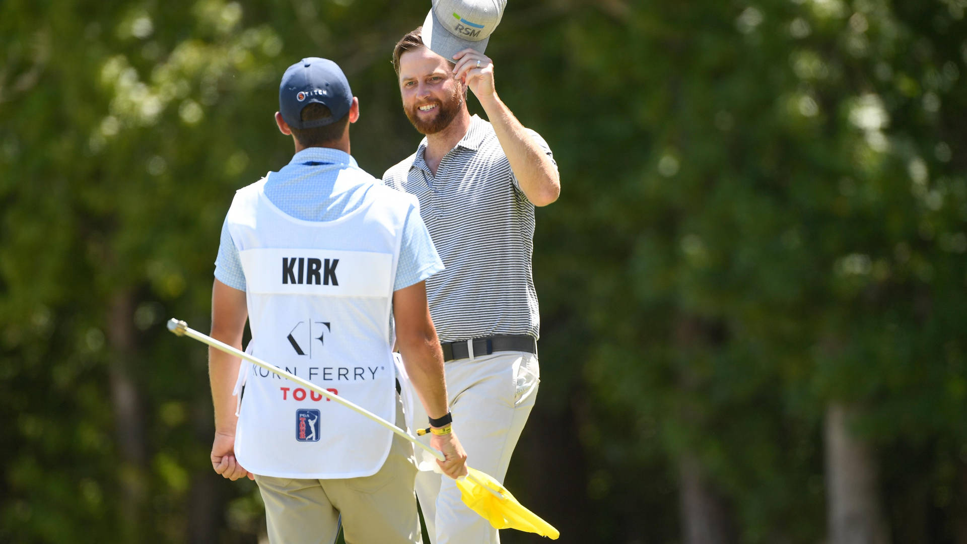 Professional golfer Chris Kirk in conversation with his caddie during a golf tournament Wallpaper
