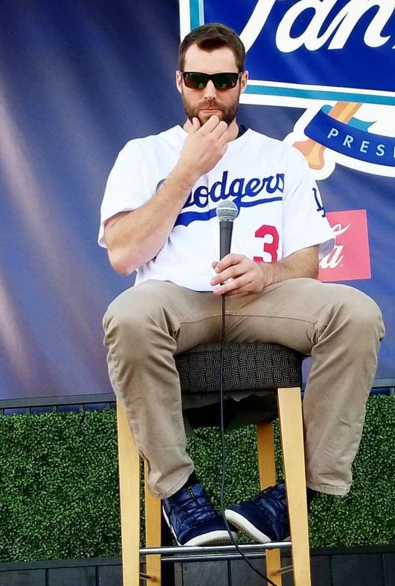 Chris Taylor Sitting Holding A Mic Background