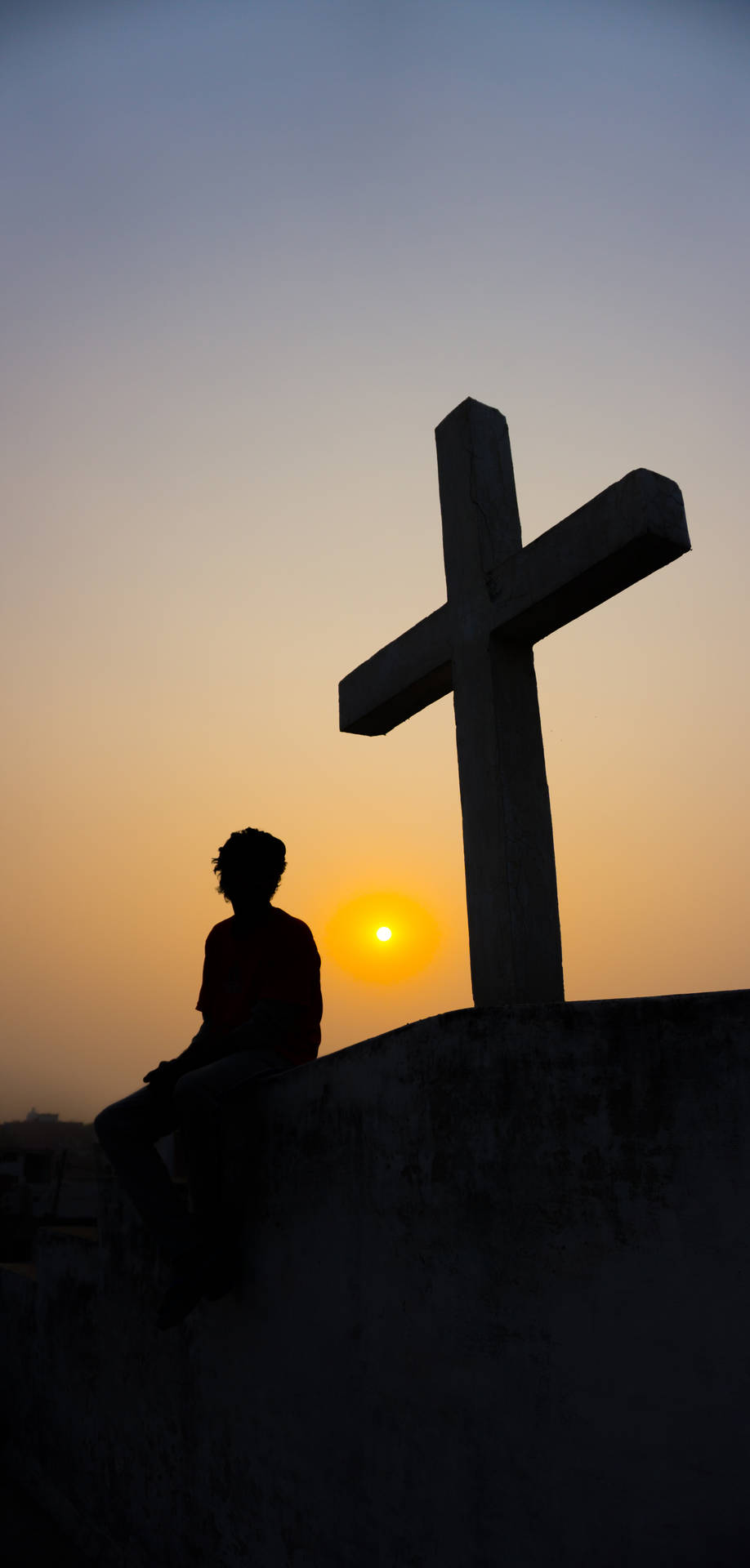 Christian Cross Against Sunset Horizon Background