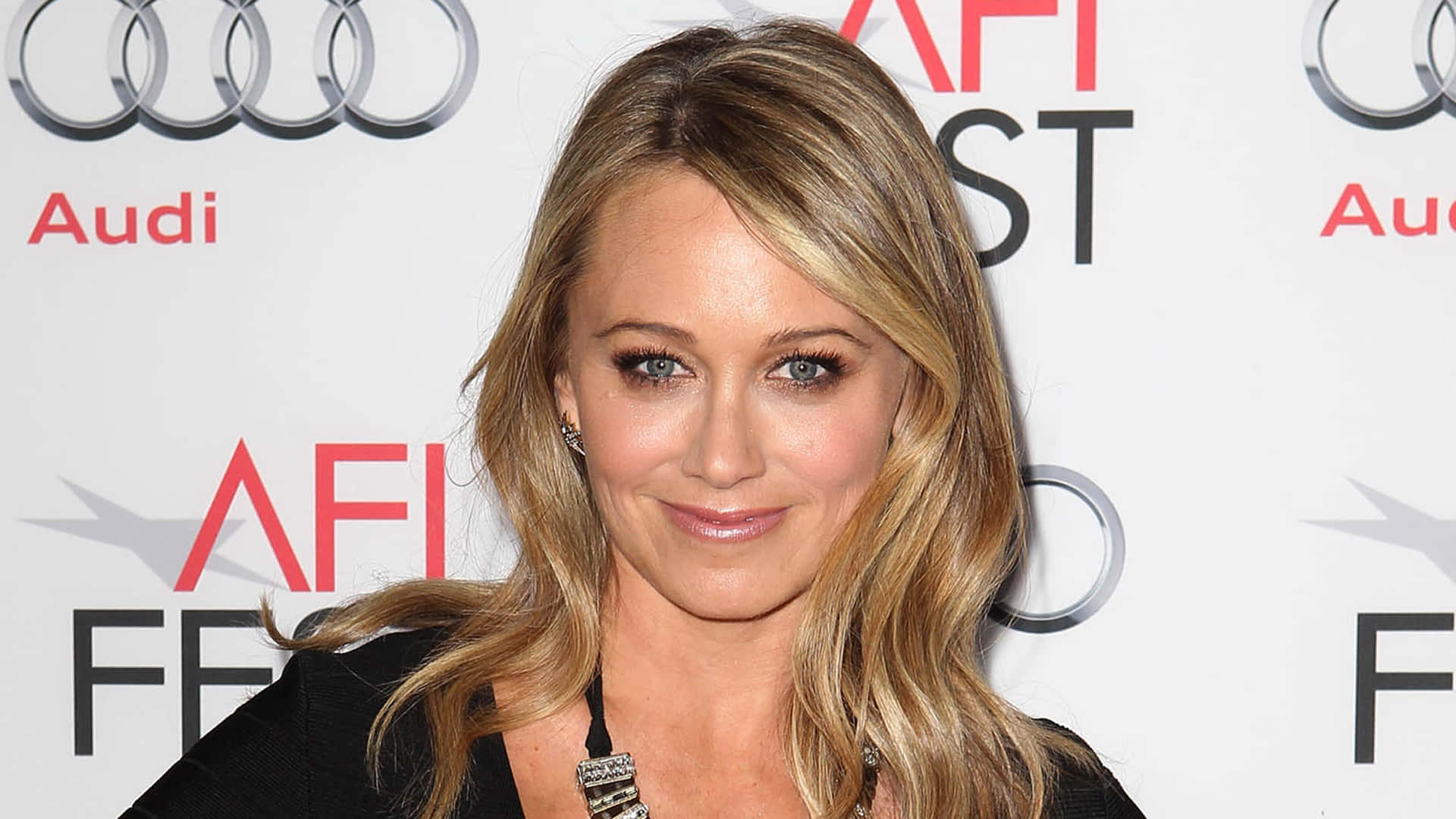 Christine Taylor Radiantly Smiling in a Casual Setting Wallpaper