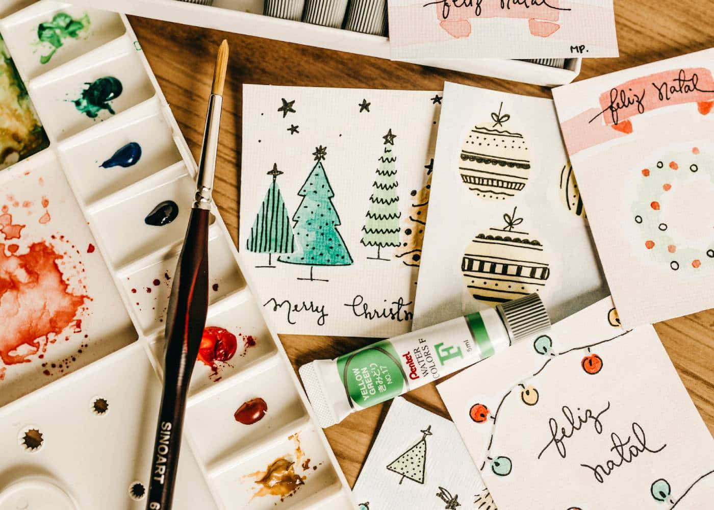 A Tray Of Paints And Brushes With Christmas Cards