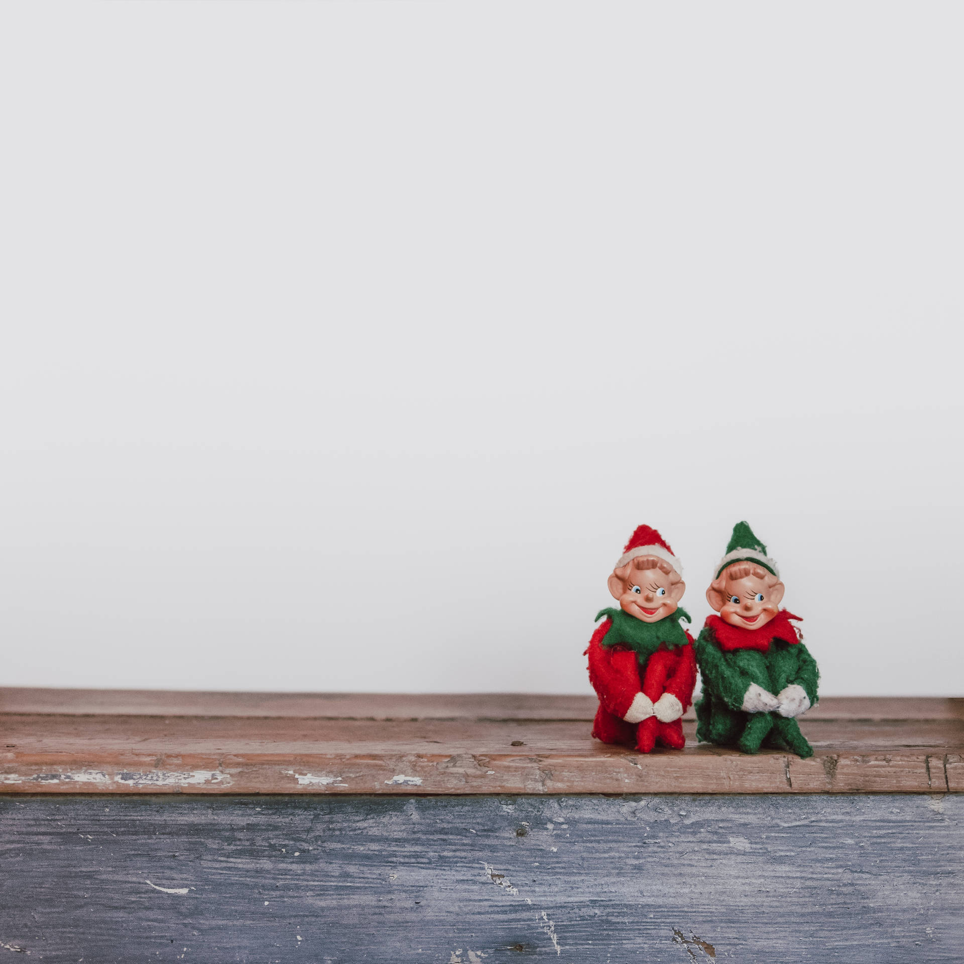 Two Elf Dummies Sitting On A Wooden Bench Wallpaper